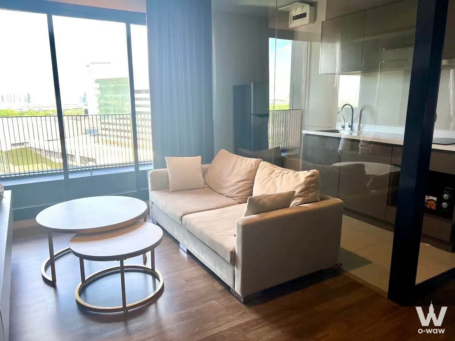 Beige sofa and glass doors in a bright 2-bed condo for rent at Life Ladprao Valley