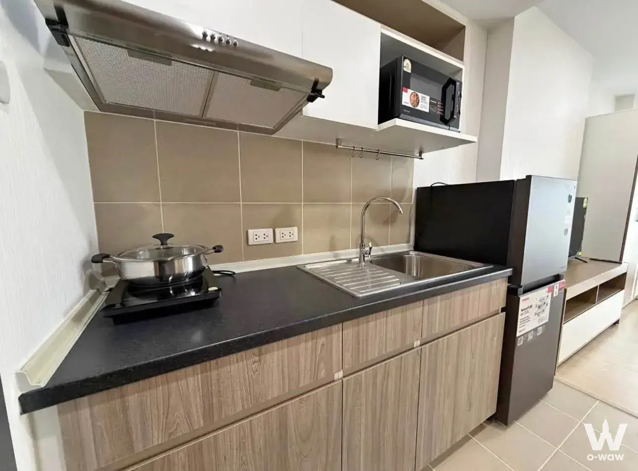 Kitchen in Supalai Veranda Ramkhamhaeng with black countertops, granite sink, and compact fridge