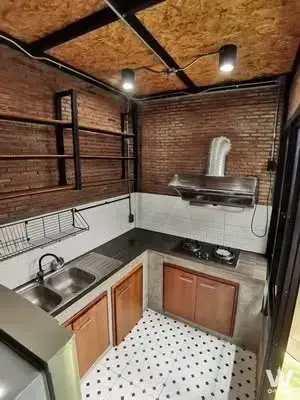 Industrial-style kitchen in a 2-bed Haus Niche townhouse with exposed brick and concrete cabinets