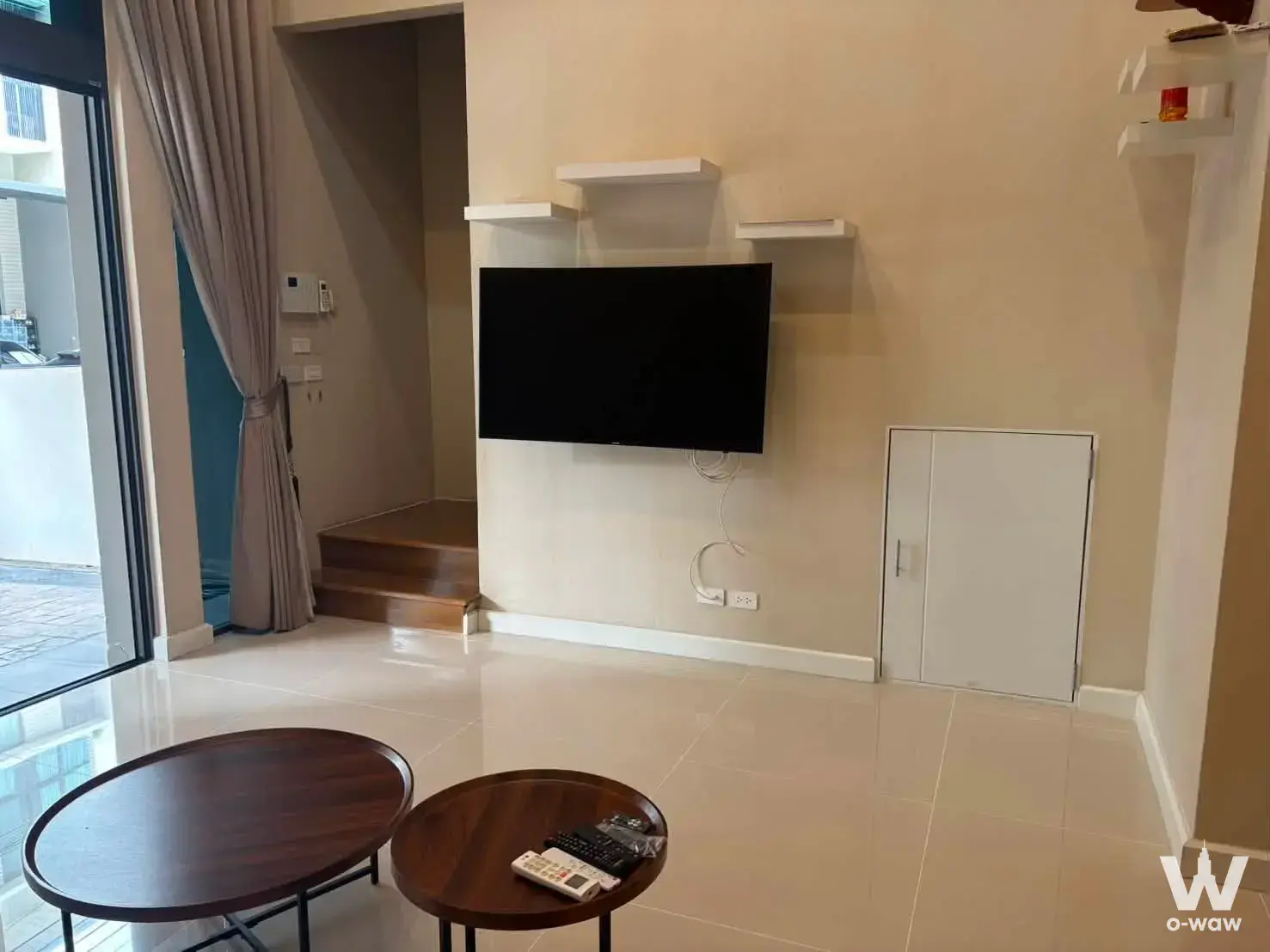 Bright living room in a 3-bed townhouse at Patio Phatthanakan 38 with glass balcony doors and floating shelves