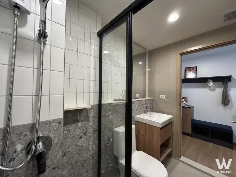 The Line Vibe bathroom featuring walk-in shower, terrazzo walls, and wooden vanity
