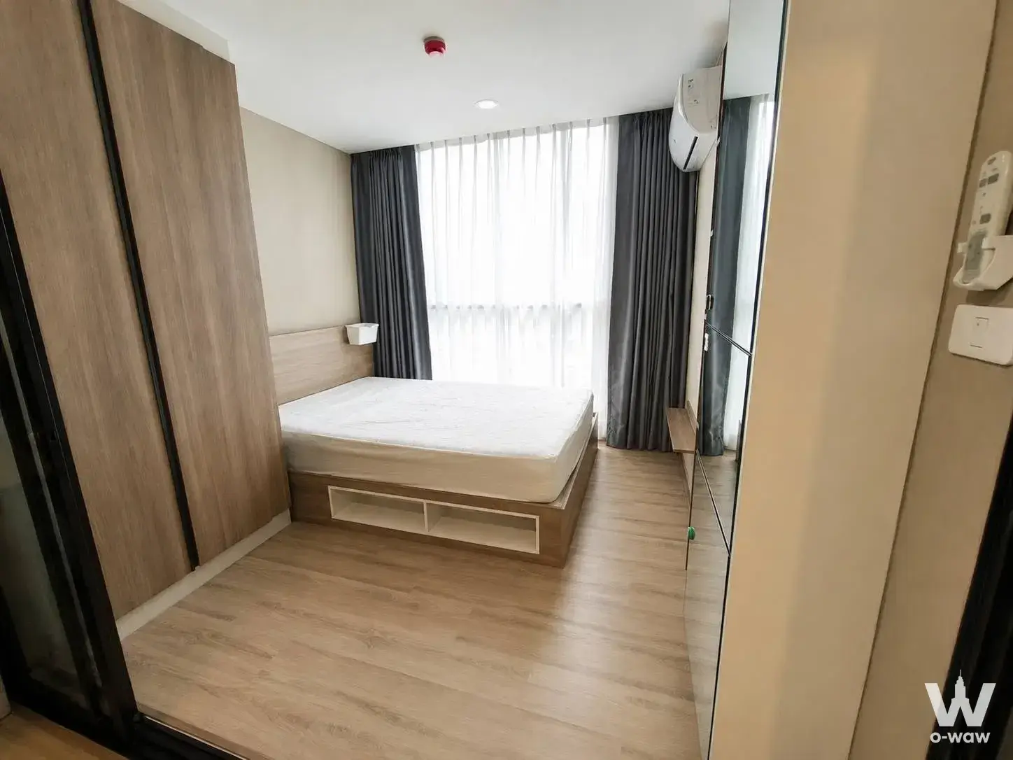Minimal bedroom in a 1-bed condo for sale at The Cube South featuring light wood wardrobe and city view