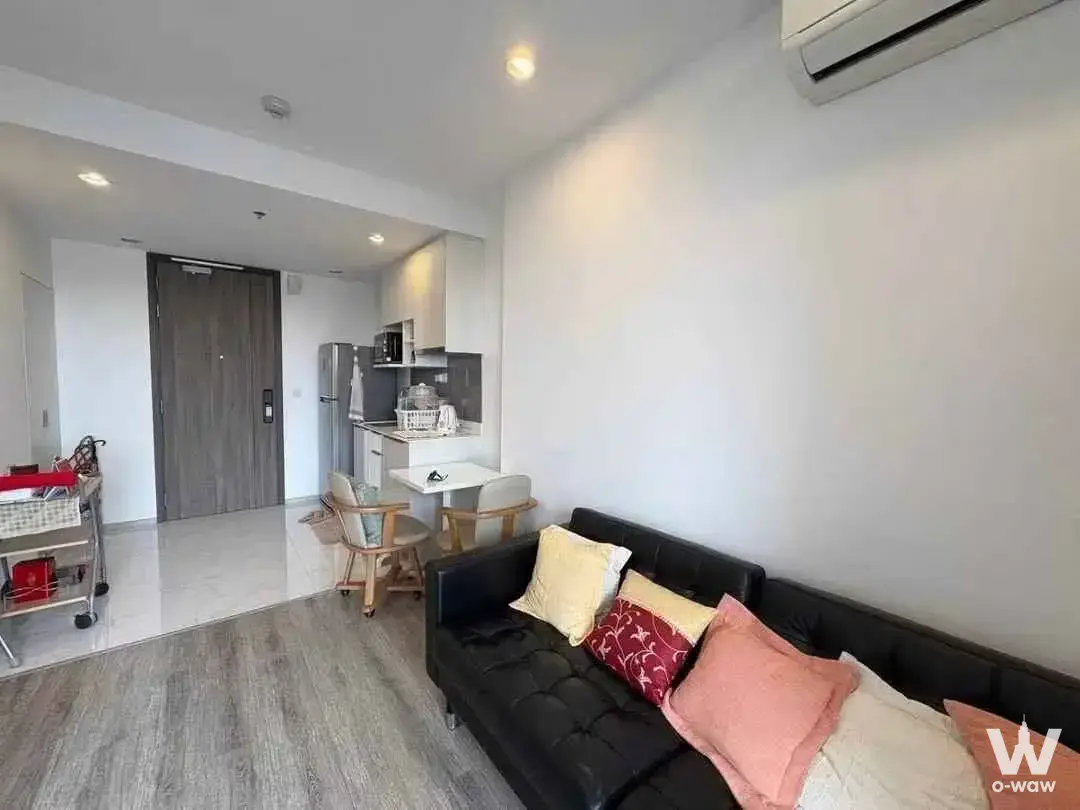 Ideo Mobi Sukhumvit 66 studio with black tufted sofa and modern kitchenette