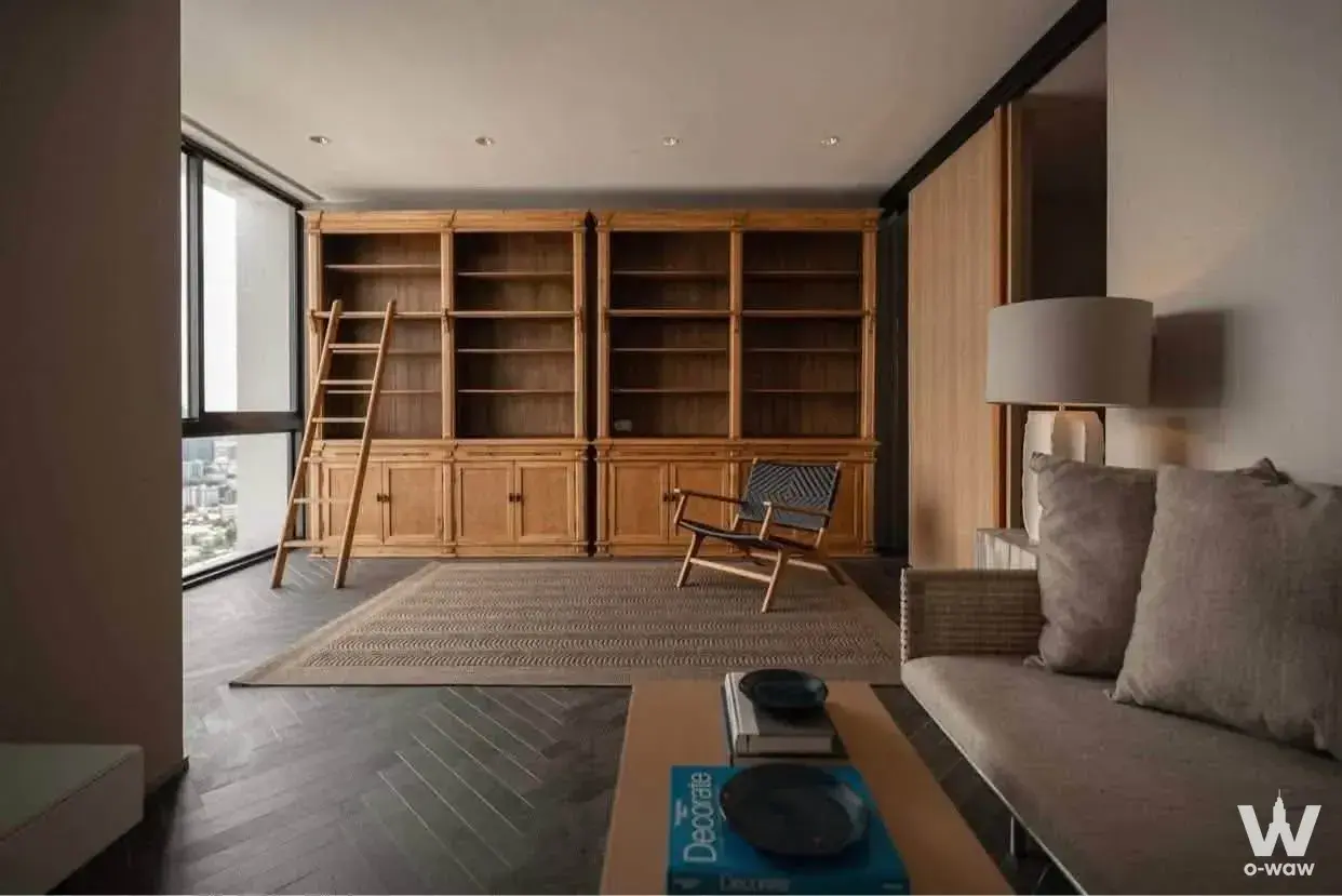 Luxury living room with bookshelf wall and city view in The Issara Ladprao