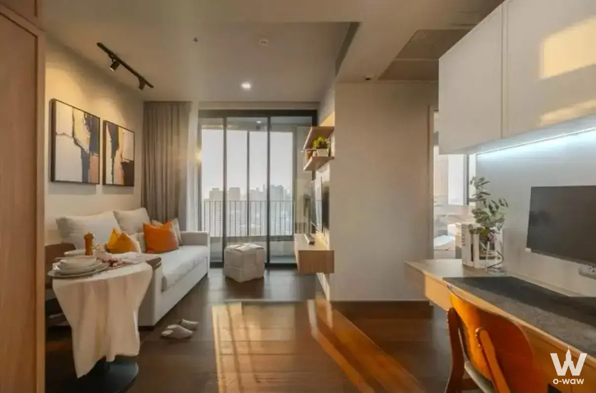 Open-plan living room in Ideo Q Sukhumvit 36 with dark wood floors and floor-to-ceiling city views