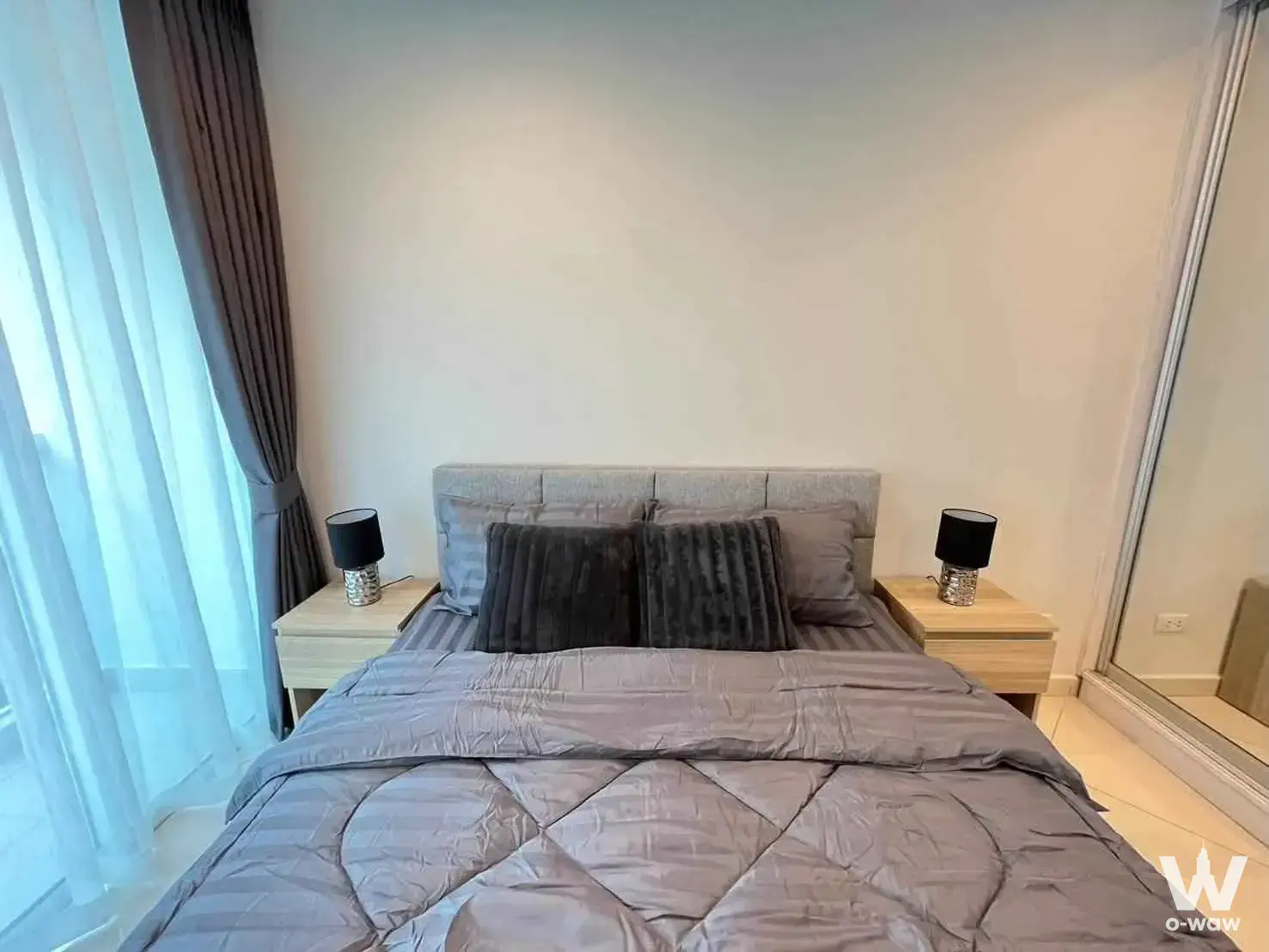 1-bed condo for sale in Art On The Hill featuring a master bedroom with grey quilted bedding and mirrored wardrobe