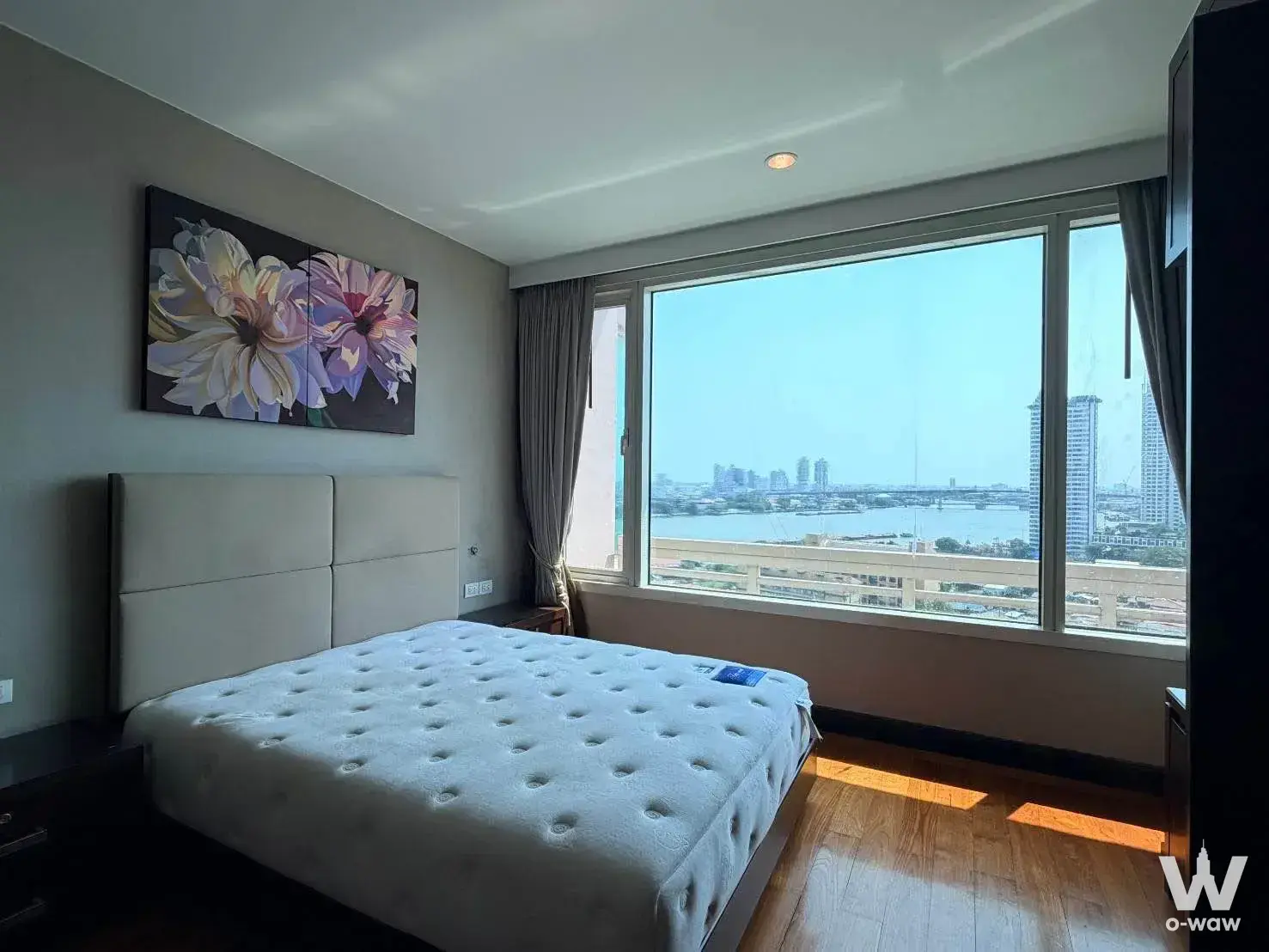 Master bedroom in a Watermark Chao Phraya 2-bed rental with river views and large floral wall art