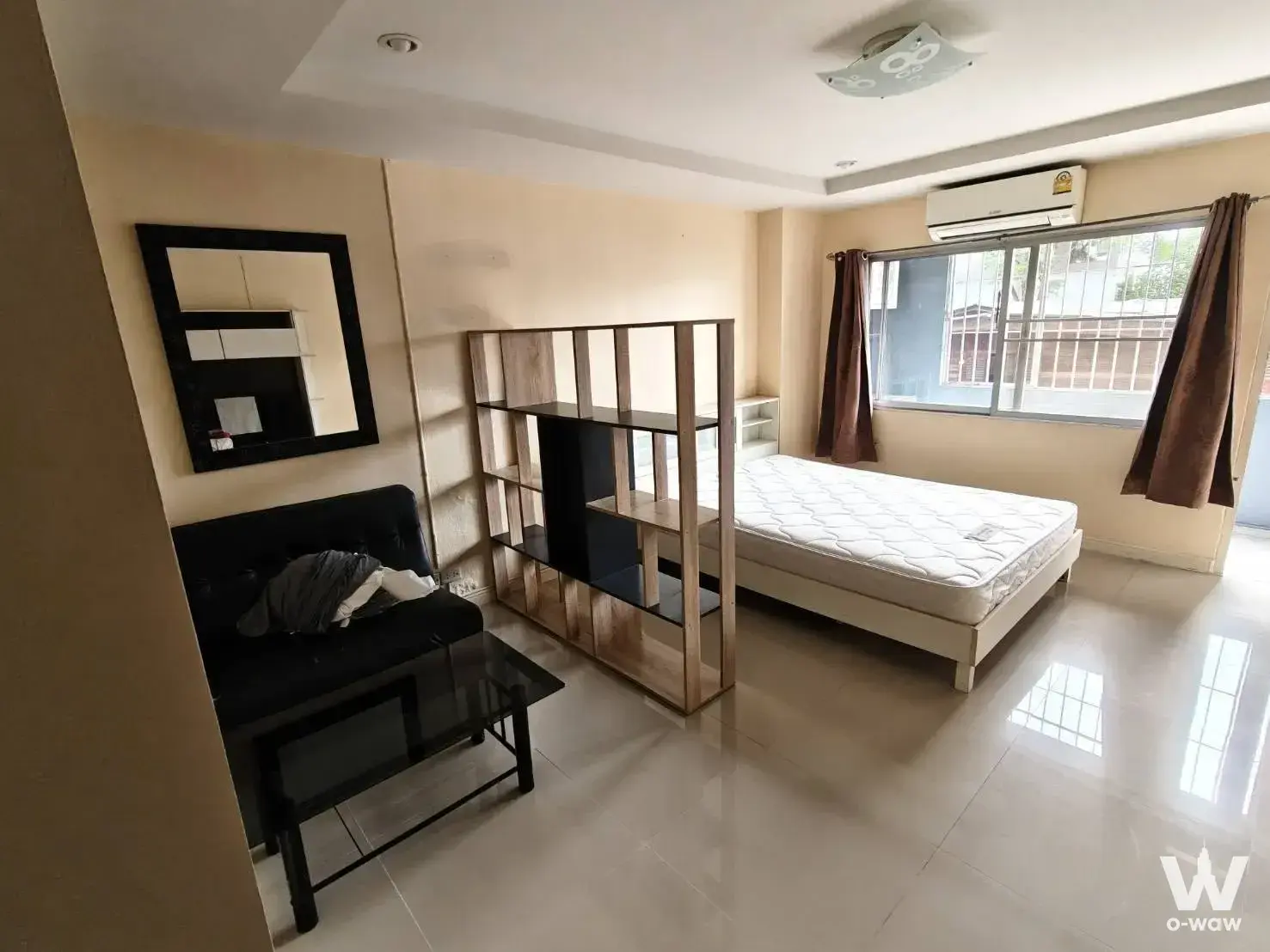 Studio layout in Ratchada Prestige Ladprao 48 with black leather sofa and wooden cube room divider