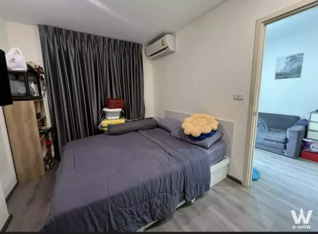 Lived-in bedroom in a Rich Park Triple Station condo with grey curtains and open shelving
