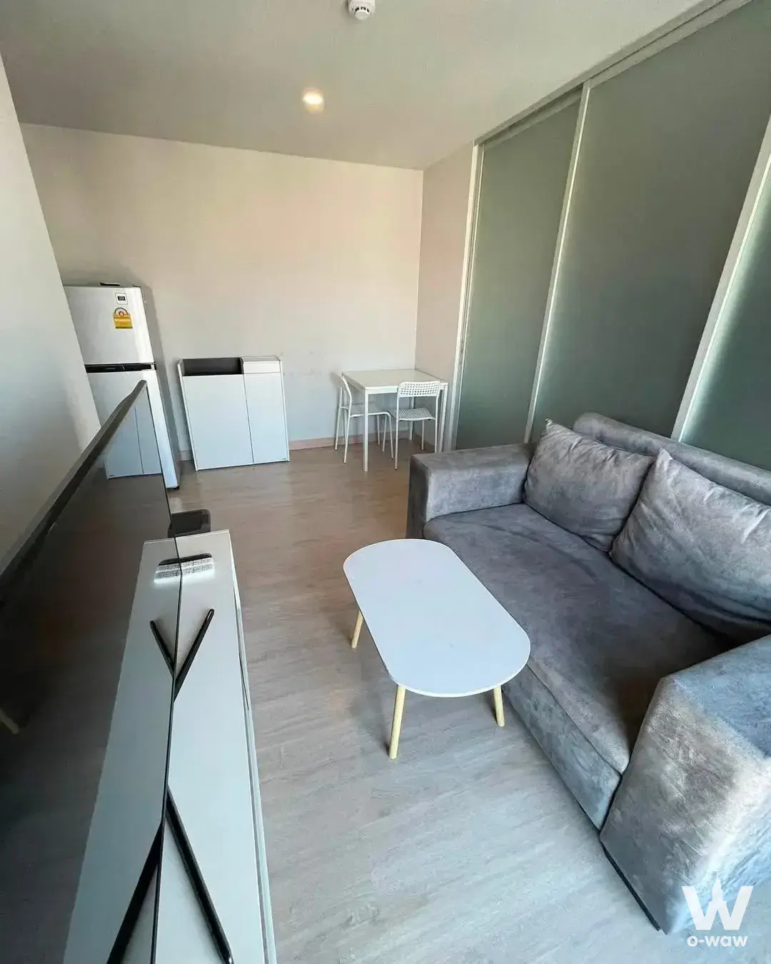 Compact living room in Lumpini Selected Sutthisan with grey sofa and wall-mounted TV