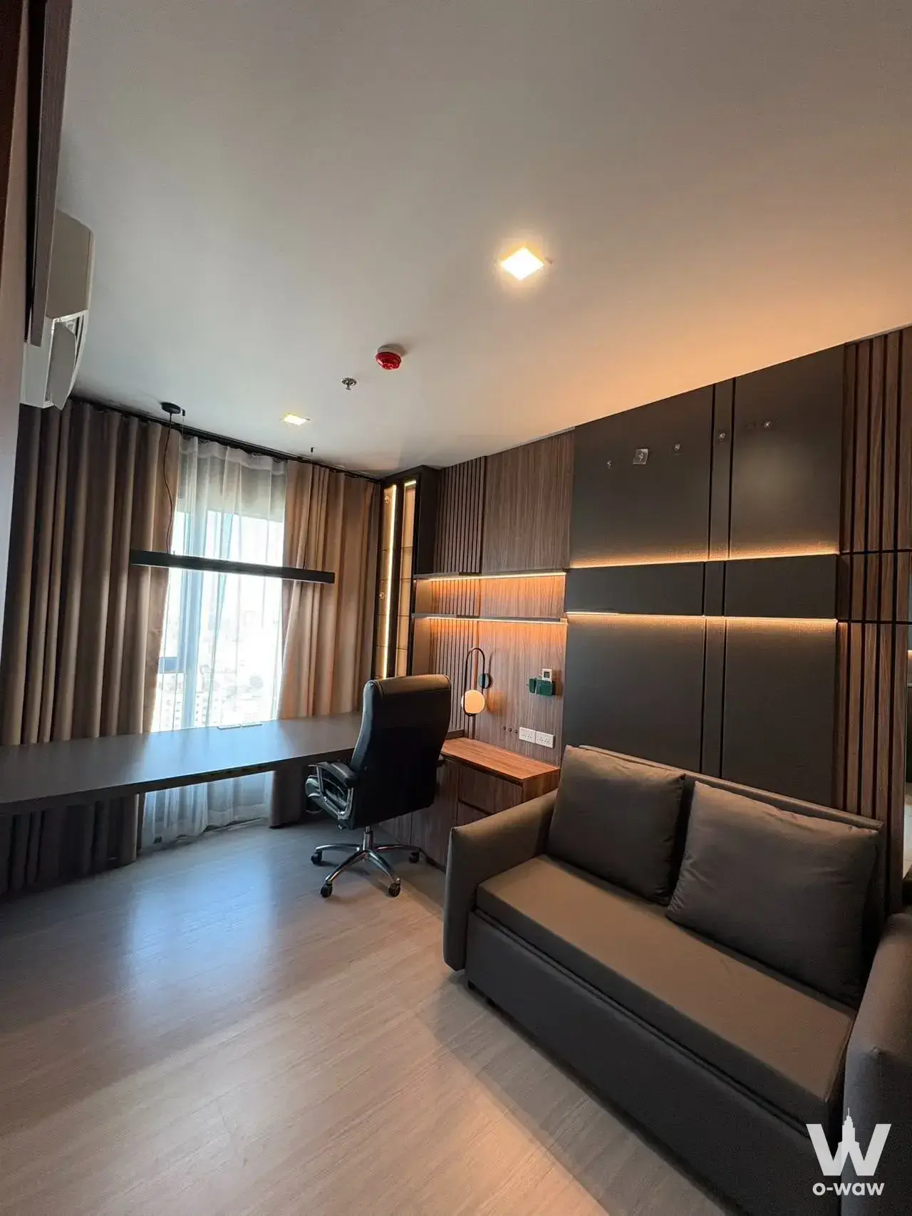 Furnished living room in a 2-bed Life Asoke condo with floor-to-ceiling windows and a built-in desk