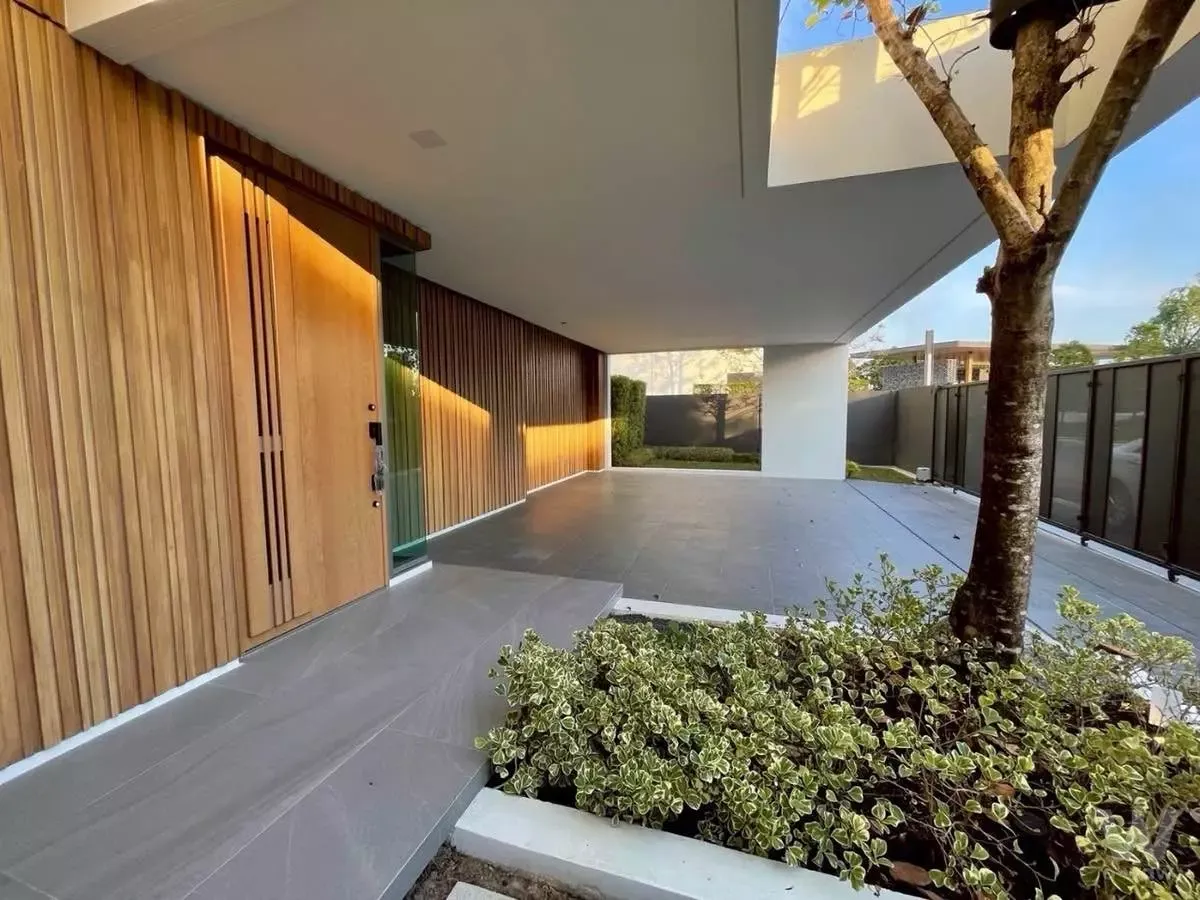 Modern villa entrance with wooden slats and stone driveway at this 4-bed house for rent in VIVE Rama 9