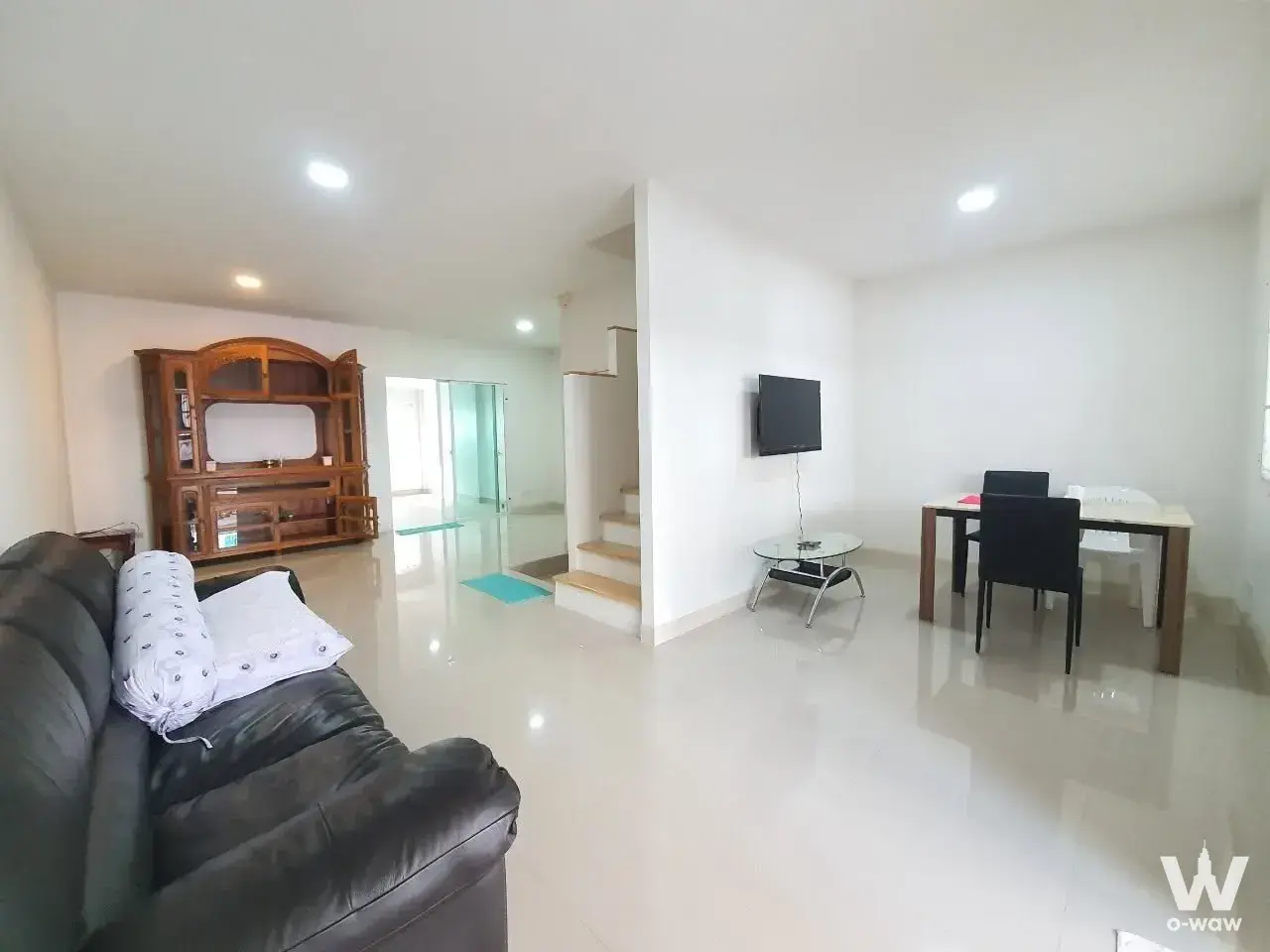 PLENO Rama 3 townhouse open-plan living area with dark leather sofa and wooden entertainment center