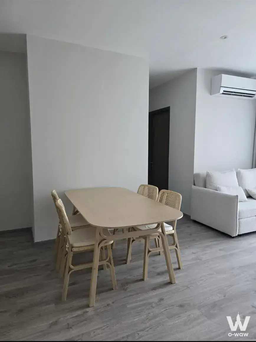 Light oak dining table with cane chairs in this Rhythm Ekkamai Estate 2-bed condo for rent