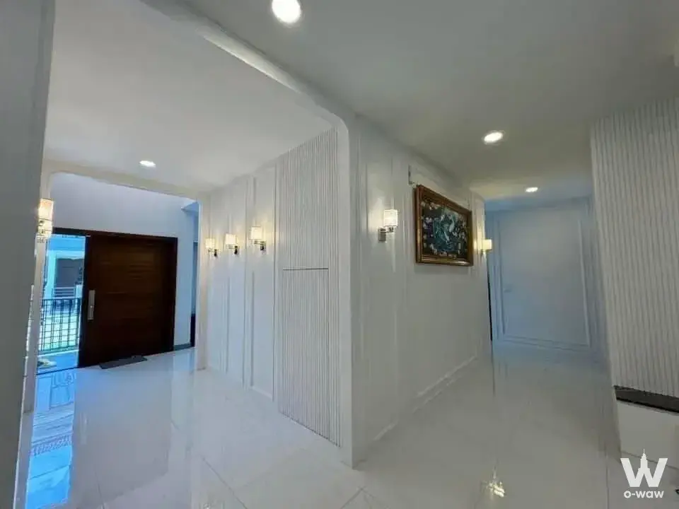 The City Bangna 4-bed house entry hallway with high-gloss white tiles and fluted wall paneling