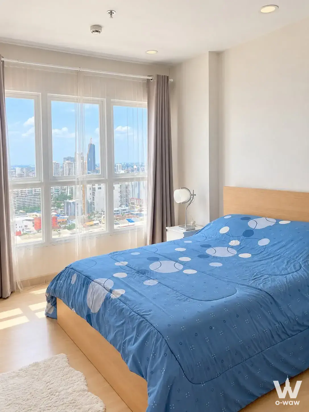 Bright bedroom with city view in a 1-bed condo for rent at Supalai Veranda Ramkhamhaeng, featuring blue accents