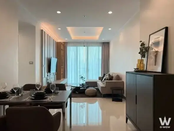 Elegant dining area in Supalai Oriental Sukhumvit 39 with wood table and warm cove lighting