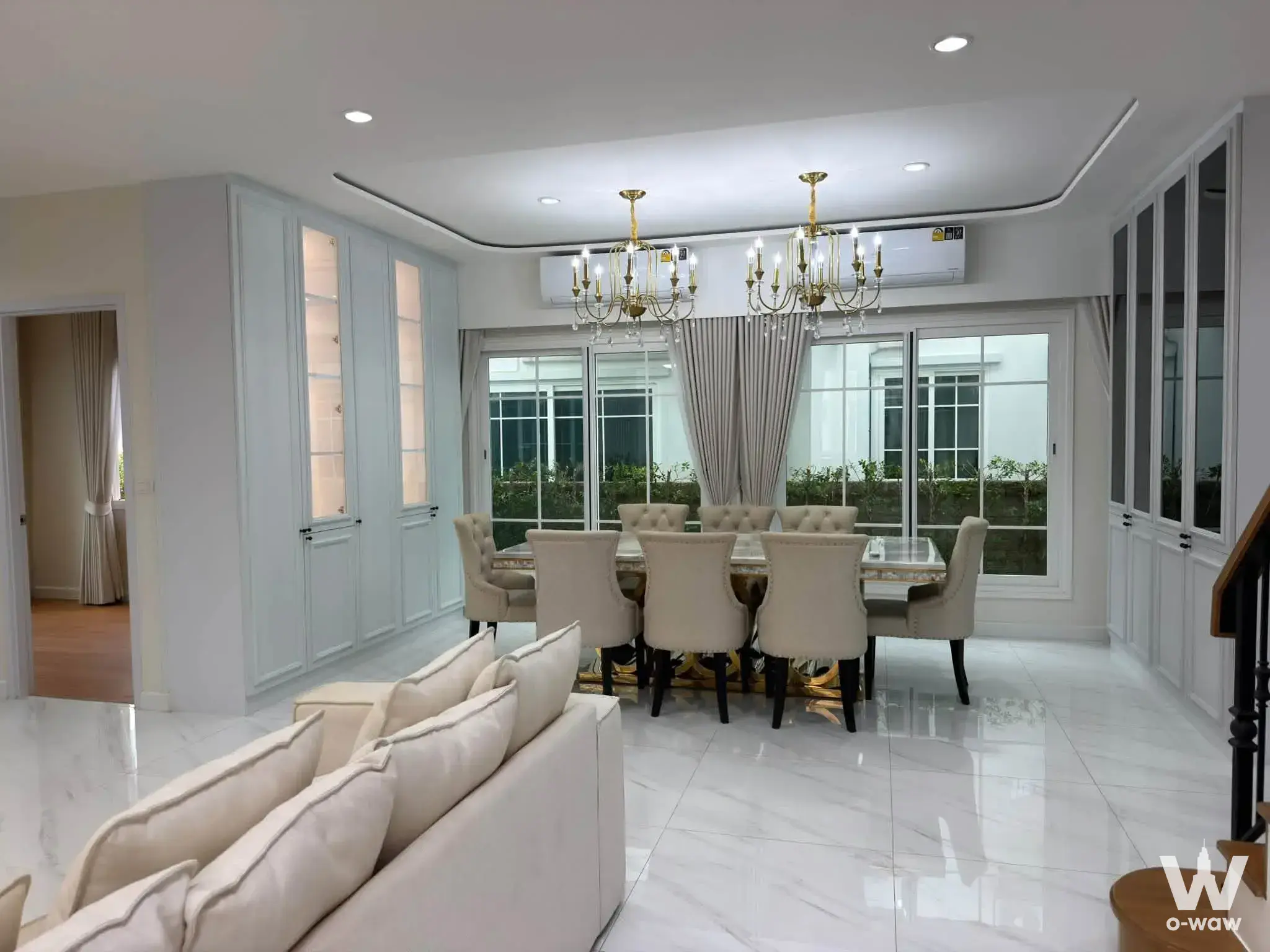 Open-plan dining area with glass table and gold chandeliers in 5-bed house for rent at Grandio Bangna KM.5
