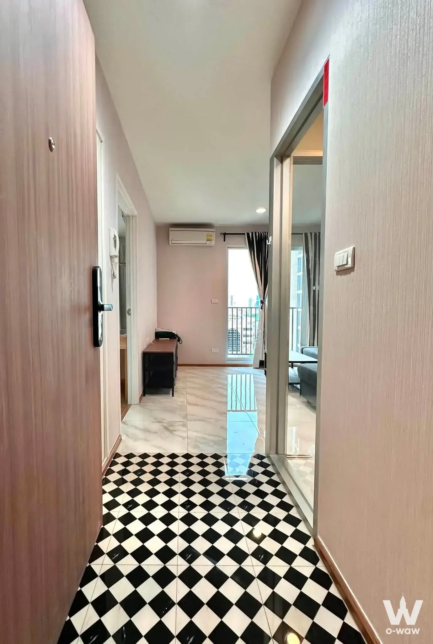 Entry hallway of a 1-bed condo in Fuse Chan Sathorn with black-white diamond tiles and a sliding glass door to the living