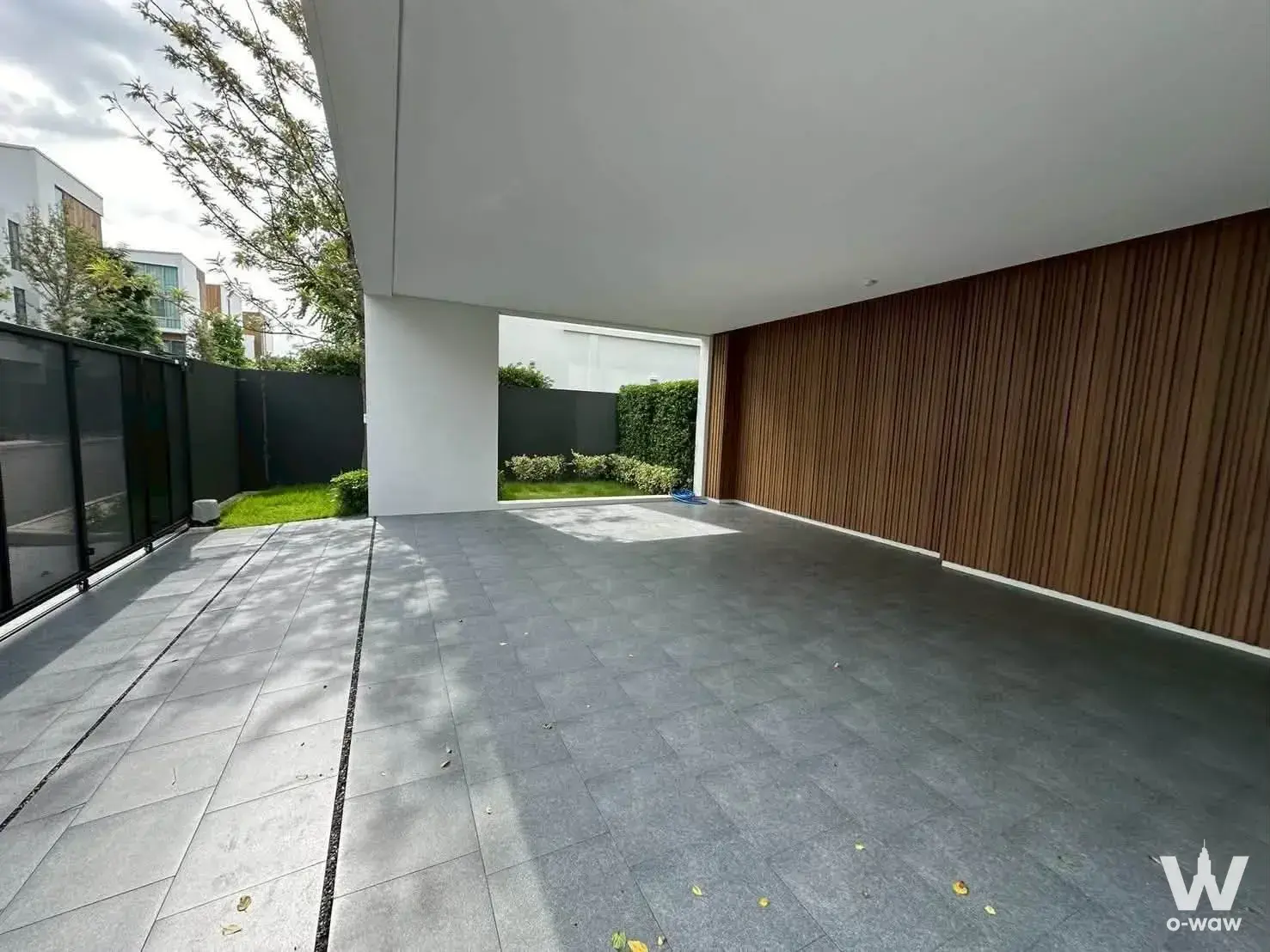 Empty outdoor terrace in VIVE Rama 9 house with wood slat screen and stone tile flooring