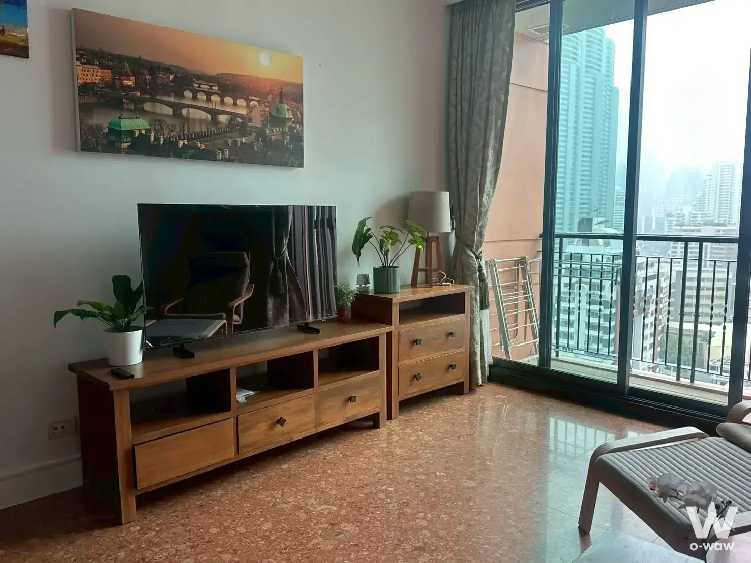 2-bed Aguston Sukhumvit 22 living room with terrazzo floors, wood console, and balcony city views