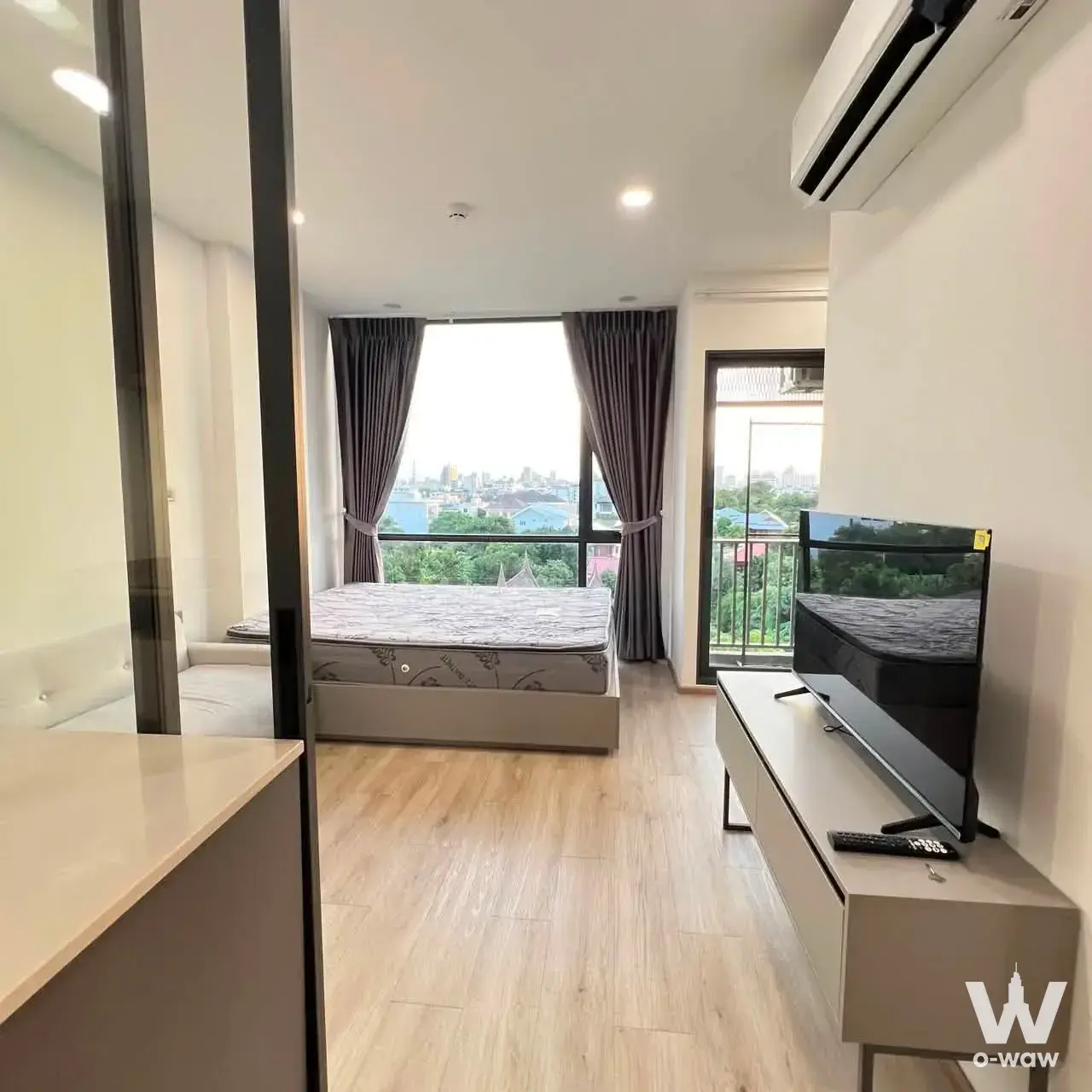 1-bed condo for sale in Groove Scape48 showing a bedroom with city skyline view through glass balcony door