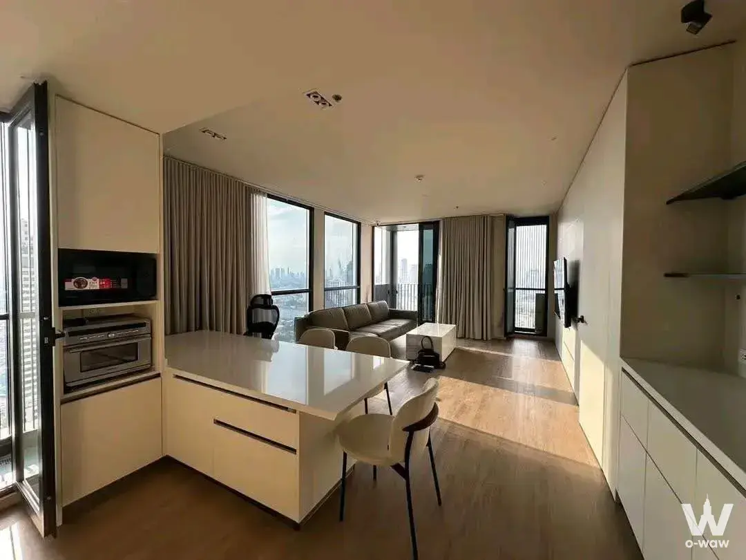 White quartz island and grey sofa in an open-plan 3-bed rental at The Issara Sathorn