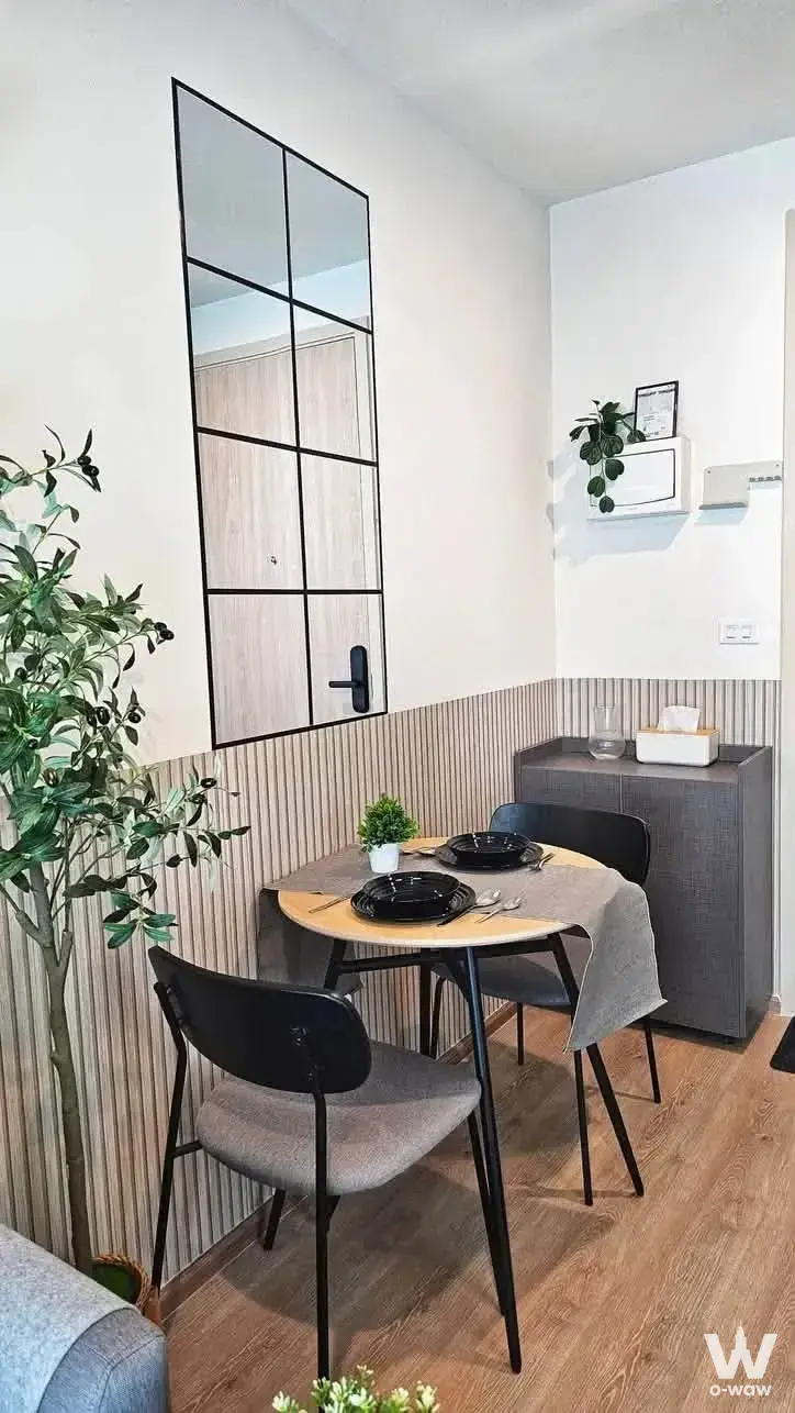 Dining nook in a 1-bed condo for rent in Nue District R9 with light wood table and black chairs
