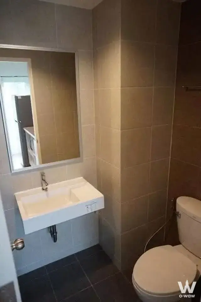 Compact bathroom in a Lumpini Park Phetkasem 98 condo with white sink and beige tiles