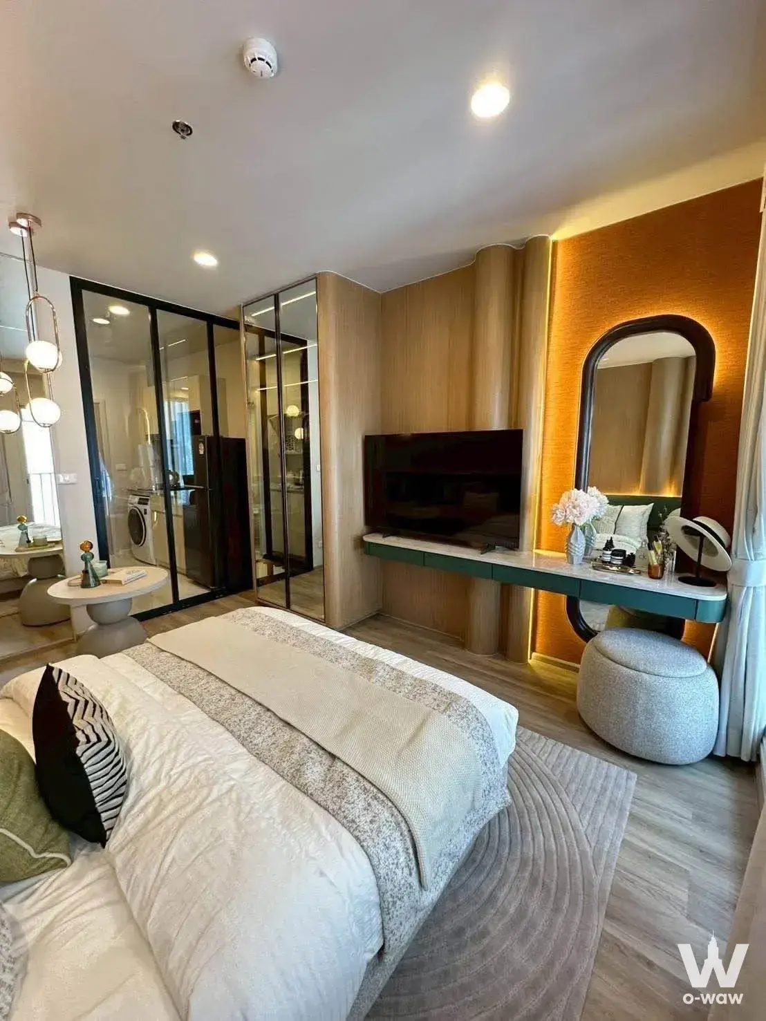 Emerald green vanity desk in a master bedroom of a Culture Thonglor 1-bed condo with arched mirror and warm lighting