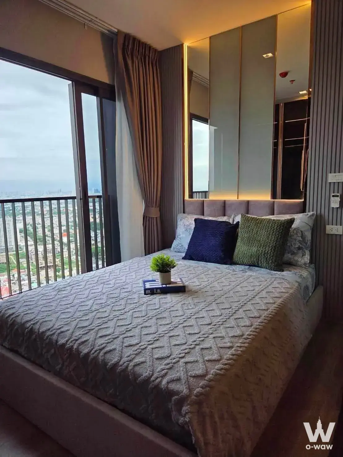 Master bedroom in The Politan Aqua 1-bed rental features a queen bed, mirrored wardrobe and city-view balcony