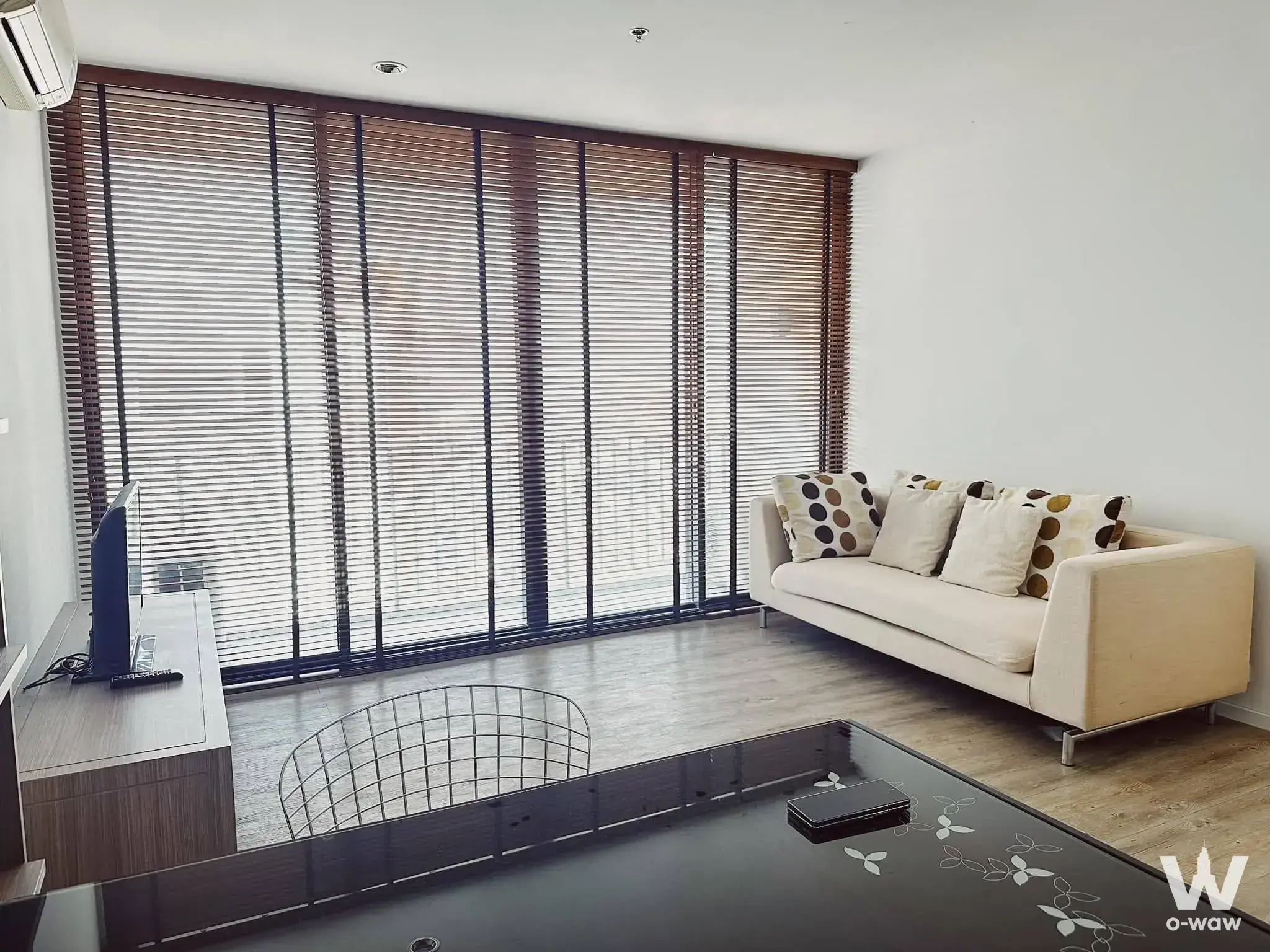 Furnished living room in The Issara Ladprao condo with cream sofa and full-height glass doors
