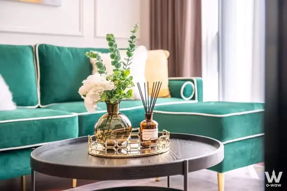 Luxury 1-bed condo living room in KHUN by YOO featuring emerald green velvet sofa and gold accents