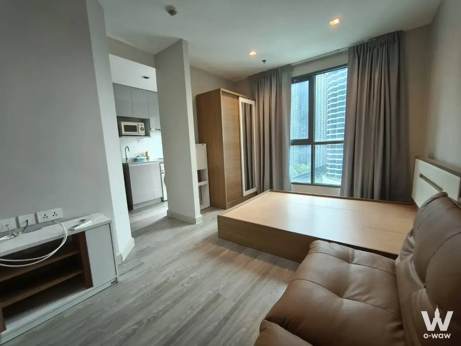 Ideo Mobi Rama 9 one-bed condo with open-plan layout, wood flooring, and high-rise city view