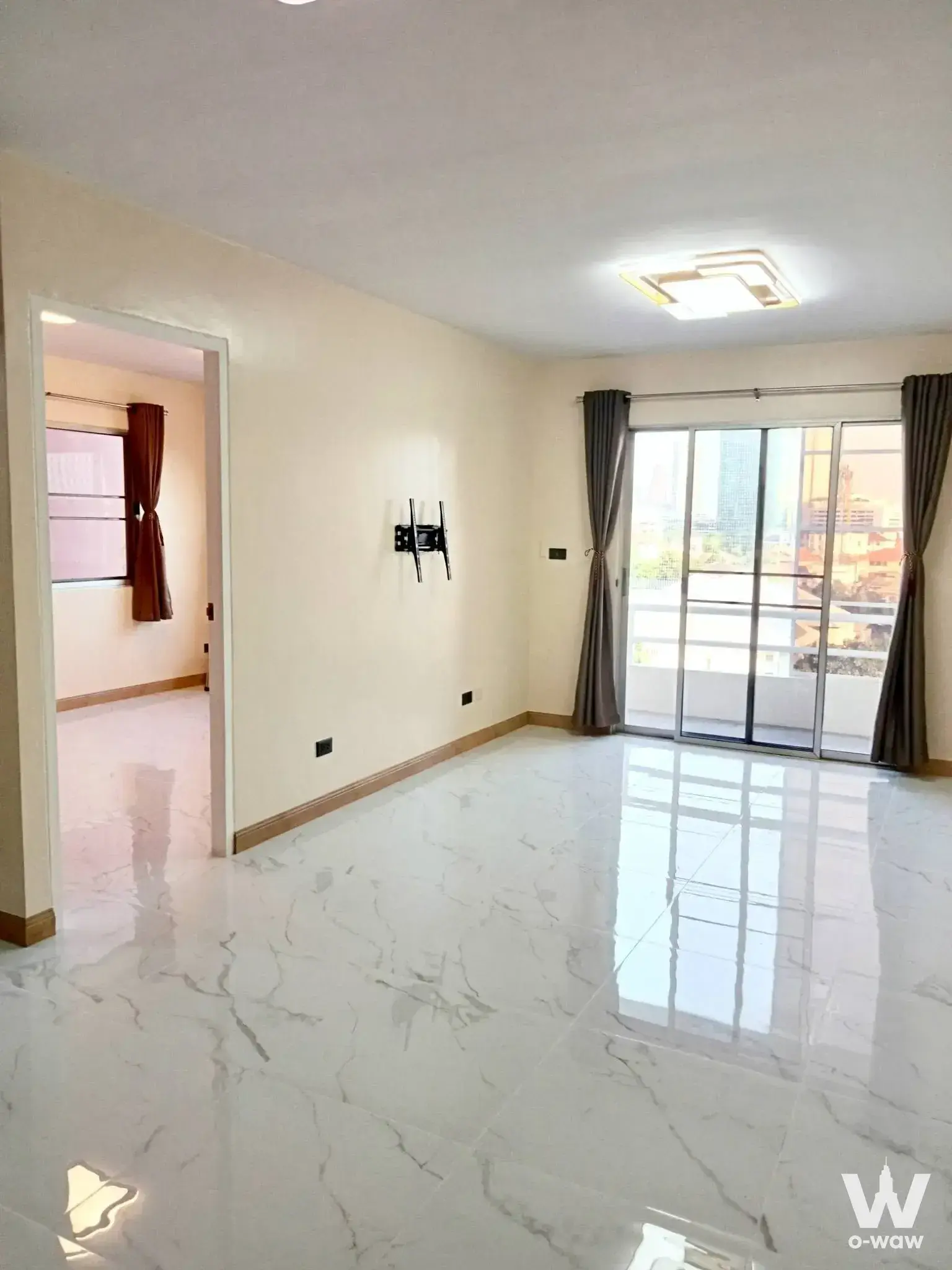 Bright empty living room in Tawanna Residence 2 with balcony city view
