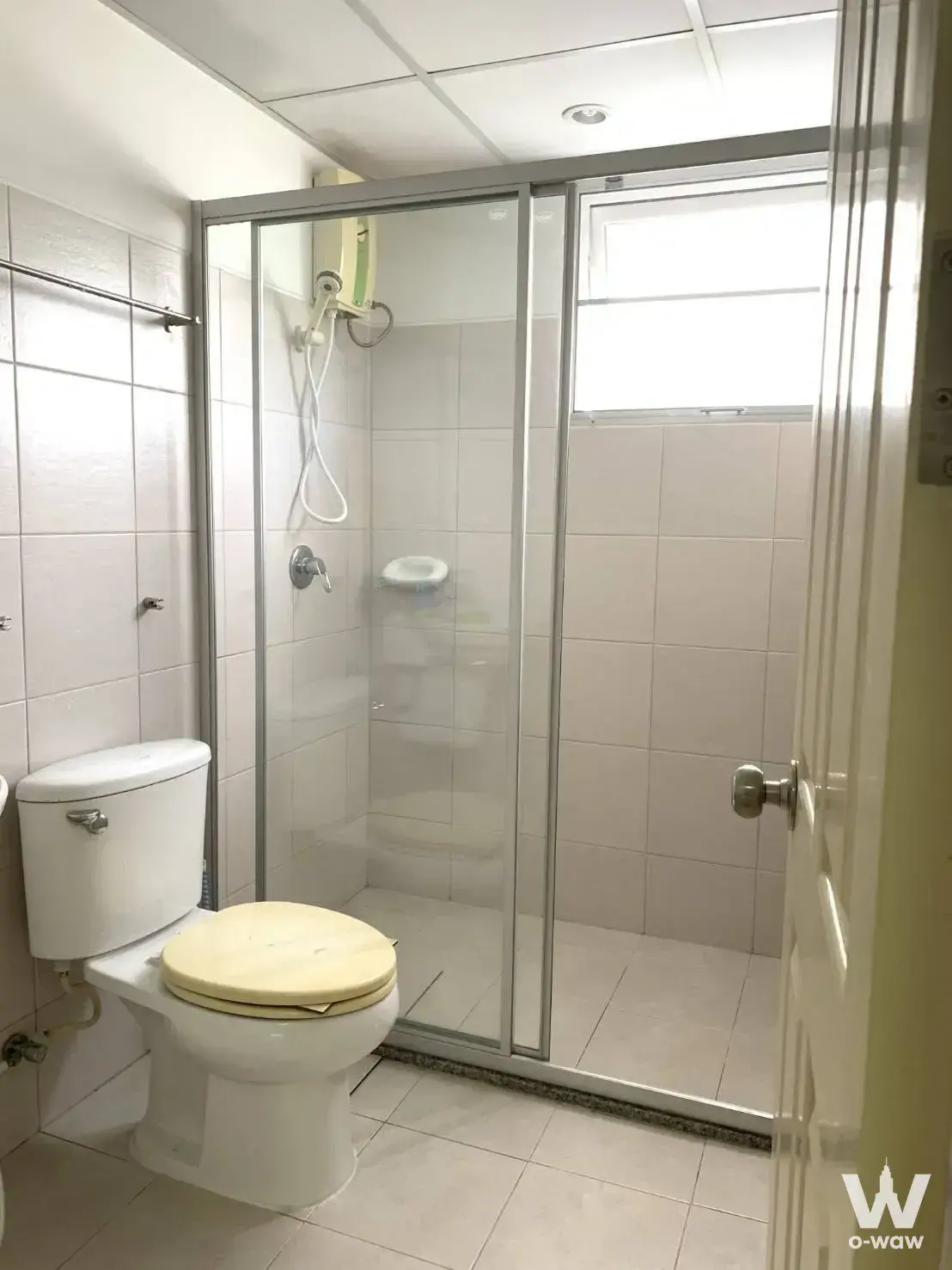 Compact bathroom with glass shower enclosure and dated fixtures in Supalai Park Kaset unit