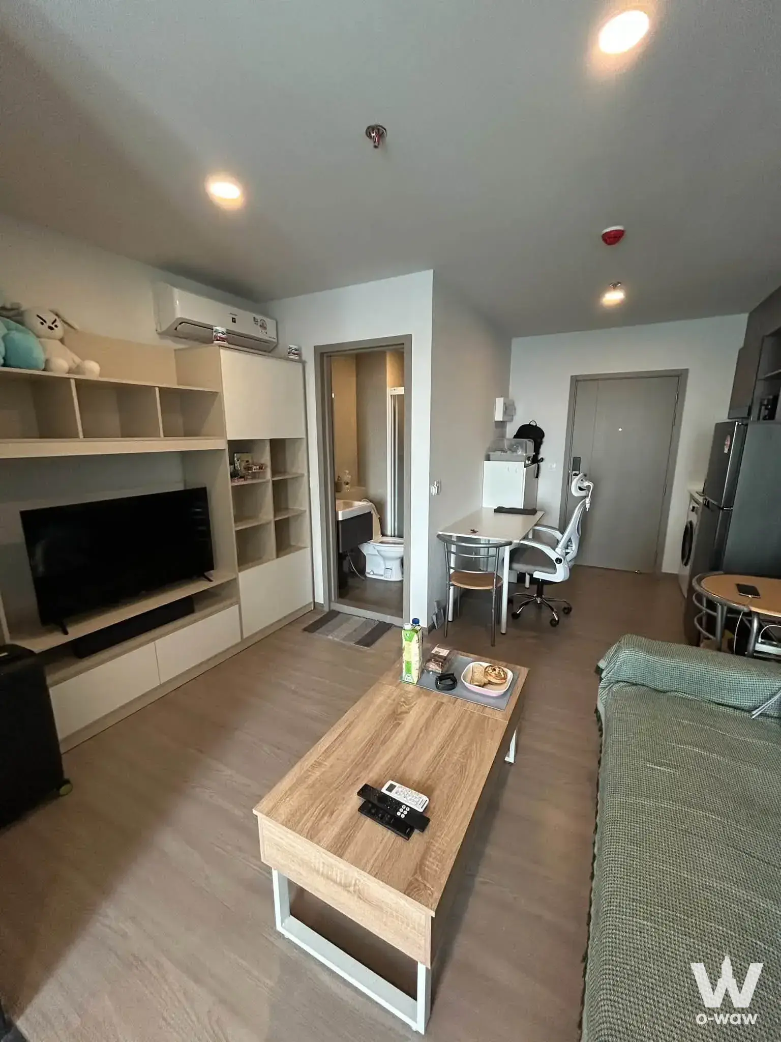 Aspire Sukhumvit-Rama 4 1-bed rental condo living room has light wood floors and built-in shelving