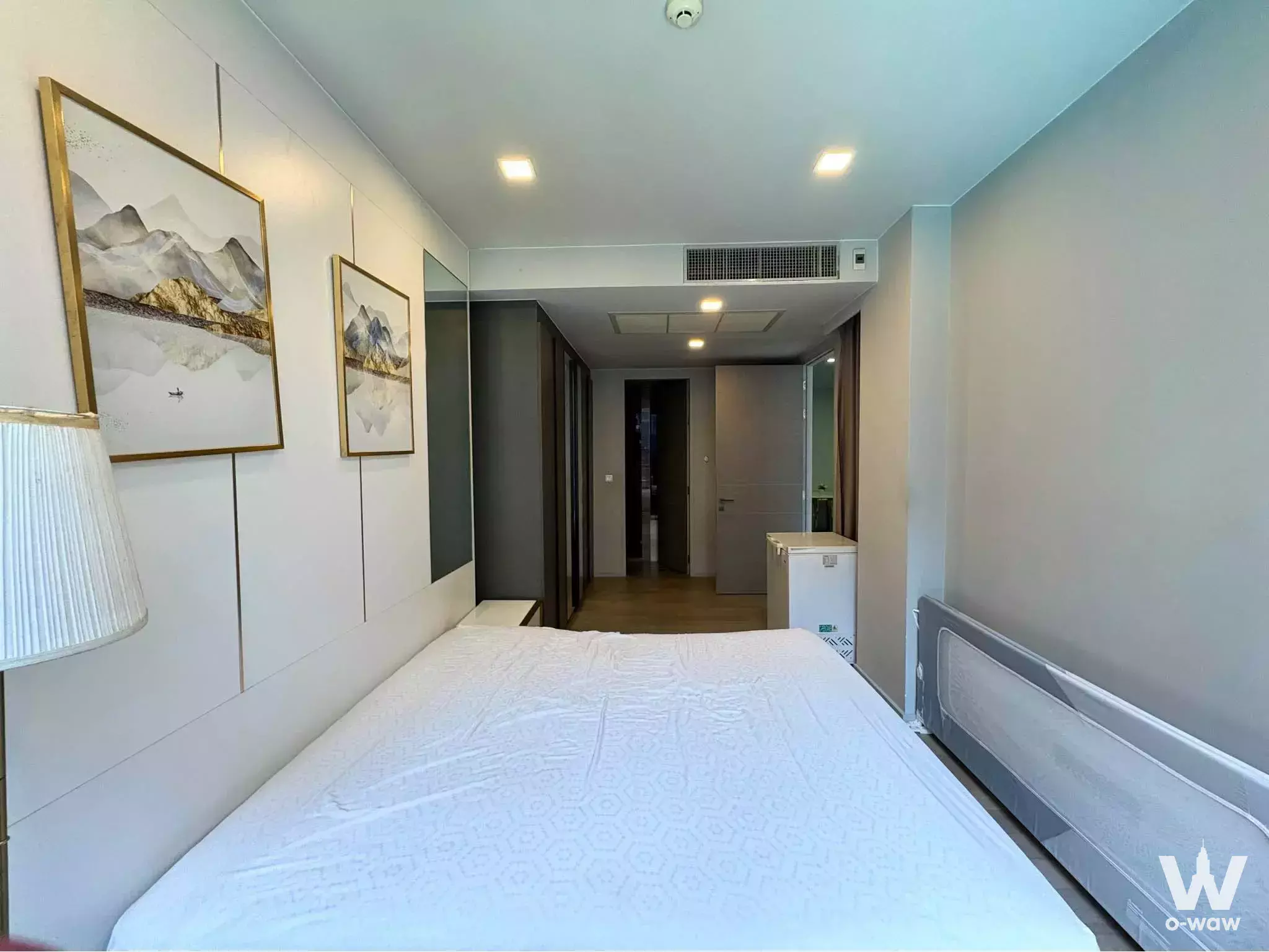Queen bed with gold-trimmed headboard and mountain art in a bedroom of Ashton Residence 41
