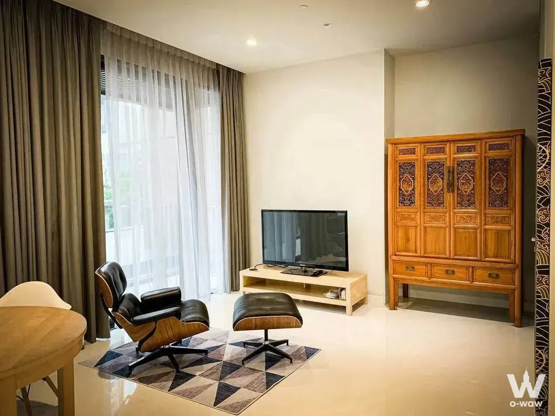 Living room with Eames lounge chair and floor-to-ceiling windows in VITTORIO Sukhumvit 39