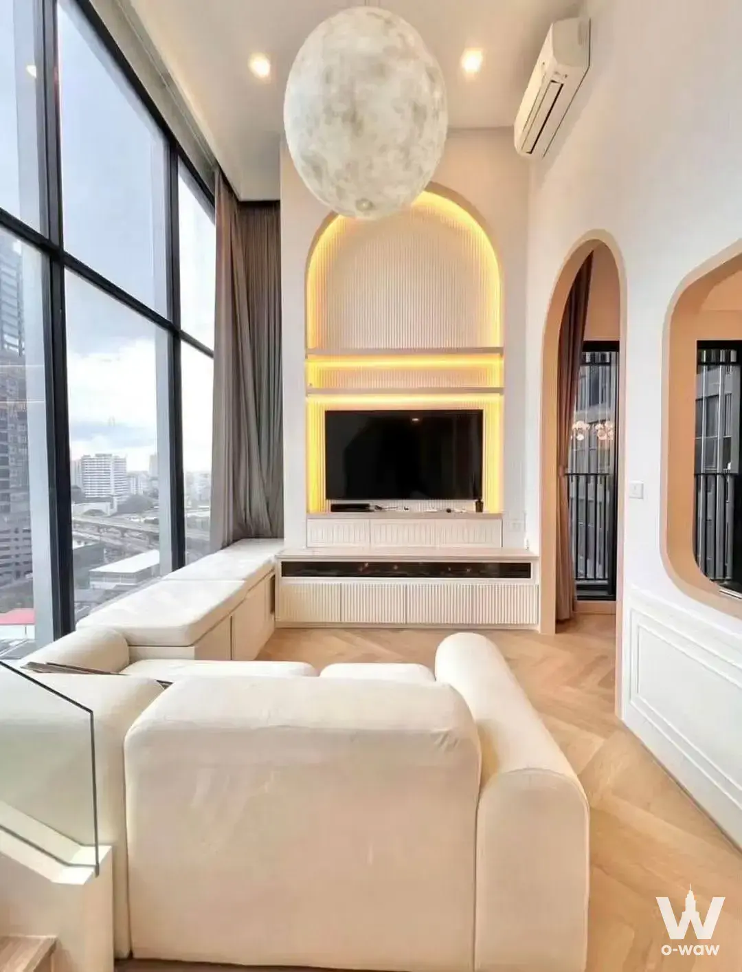 Modern luxury living room with arched niche and city skyline view in a 2-bed unit for rent in Culture Chula