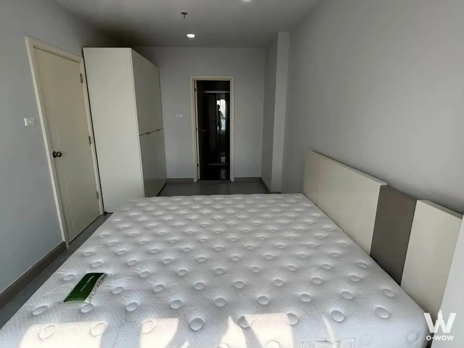 Bedroom in a Supalai Veranda Phasi Charoen condo with a queen bed, geometric headboard, and tall white wardrobe