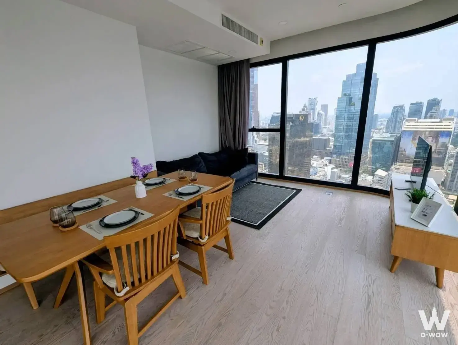 Ashton Chula-Silom 2-bed condo open-plan living area with city skyline view through floor-to-ceiling windows