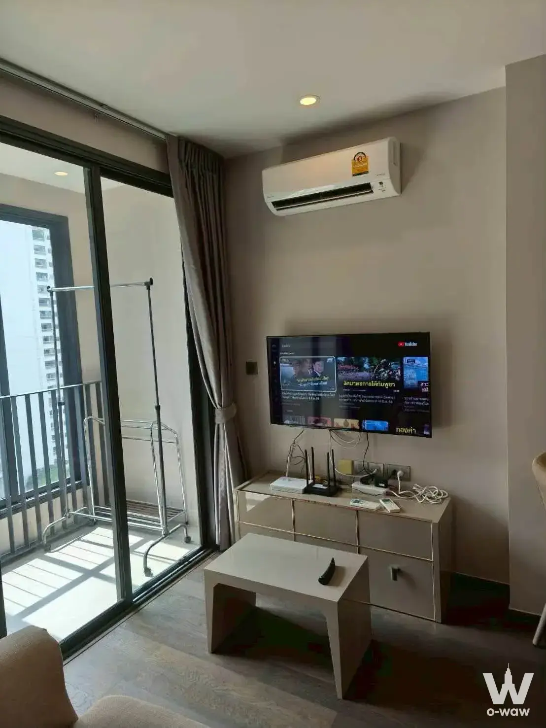 IDE0 Rama 9 Asoke 1-bed condo living room with TV console and balcony access