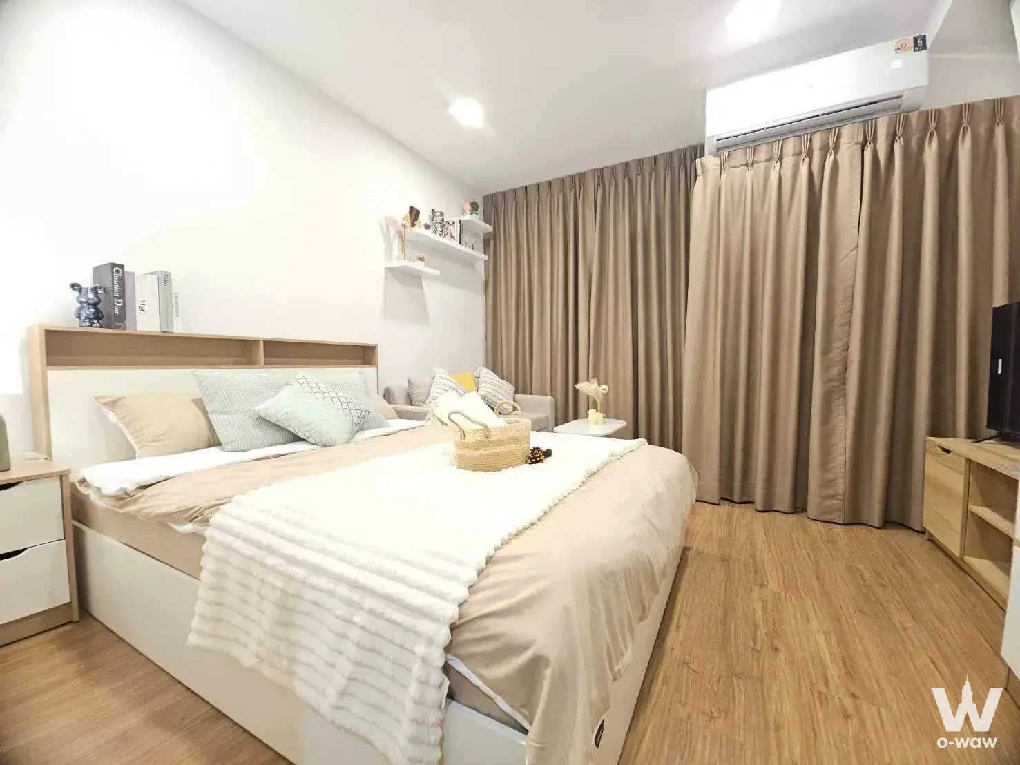 Bright bedroom in a 1-bed condo at The Livin Ramkhamhaeng with a queen bed and light wood headboard shelf