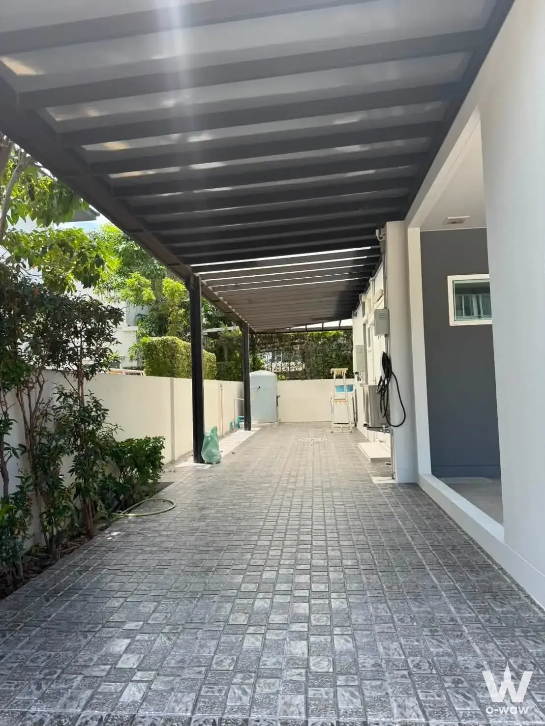 Covered outdoor walkway with metal pergola roof at this 4-bed Mantana 2 Bangna house