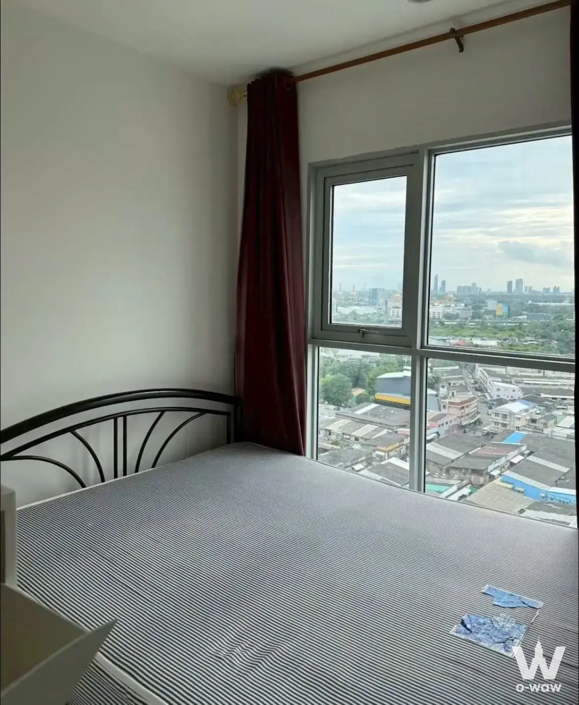 Queen bed with black metal headboard in a 1-bed condo for rent at Aspire Sukhumvit 48