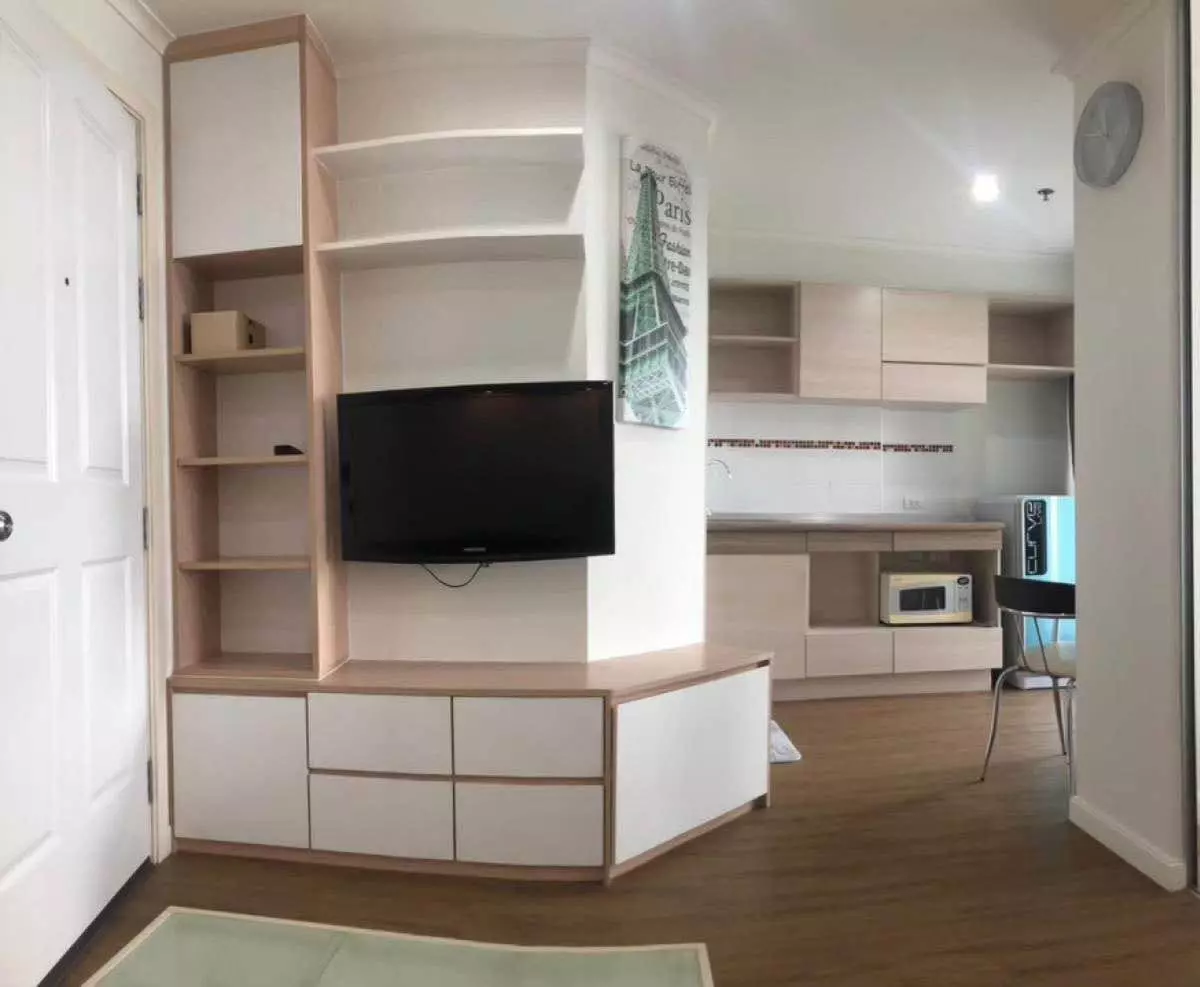 Living room with media unit and open kitchen in Lumpini Place Rama 8 1-bed condo for rent