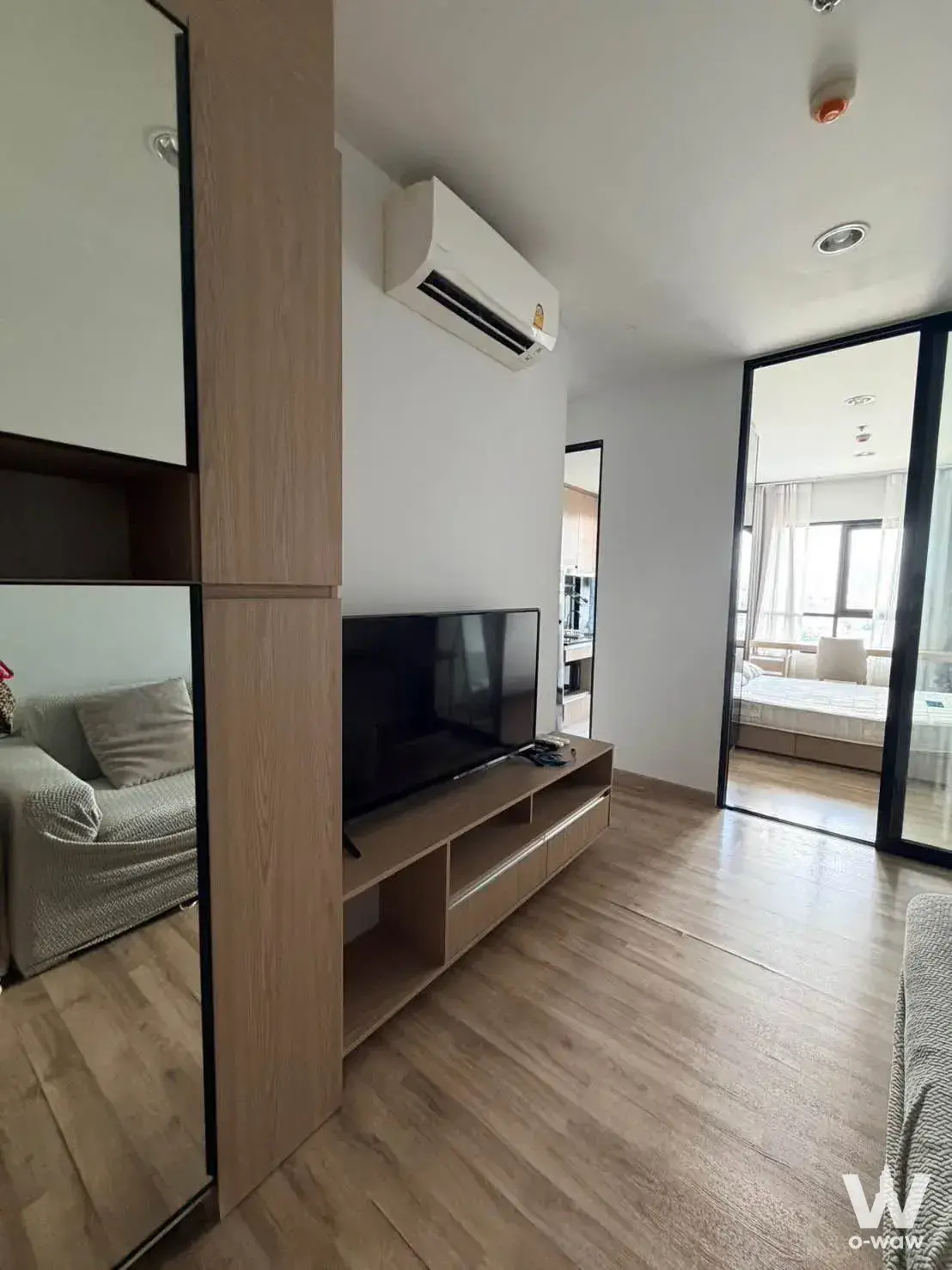 1-bed other for rent in Niche MONO Sukhumvit Bearing showing a living room with mirrored partition cabinets and a view into