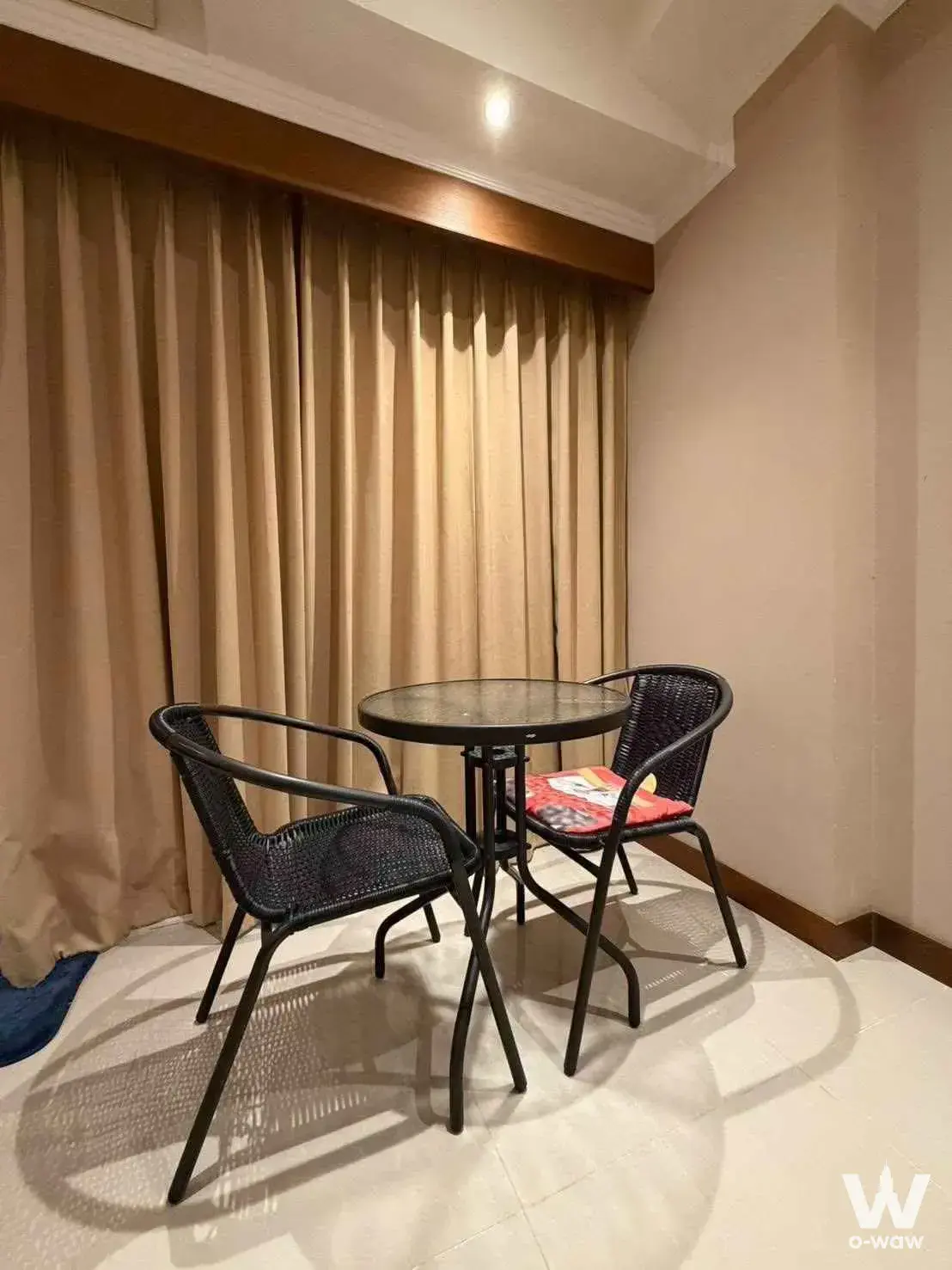 Cozy dining nook in View Talay 5C with black wicker chairs and glass-top table
