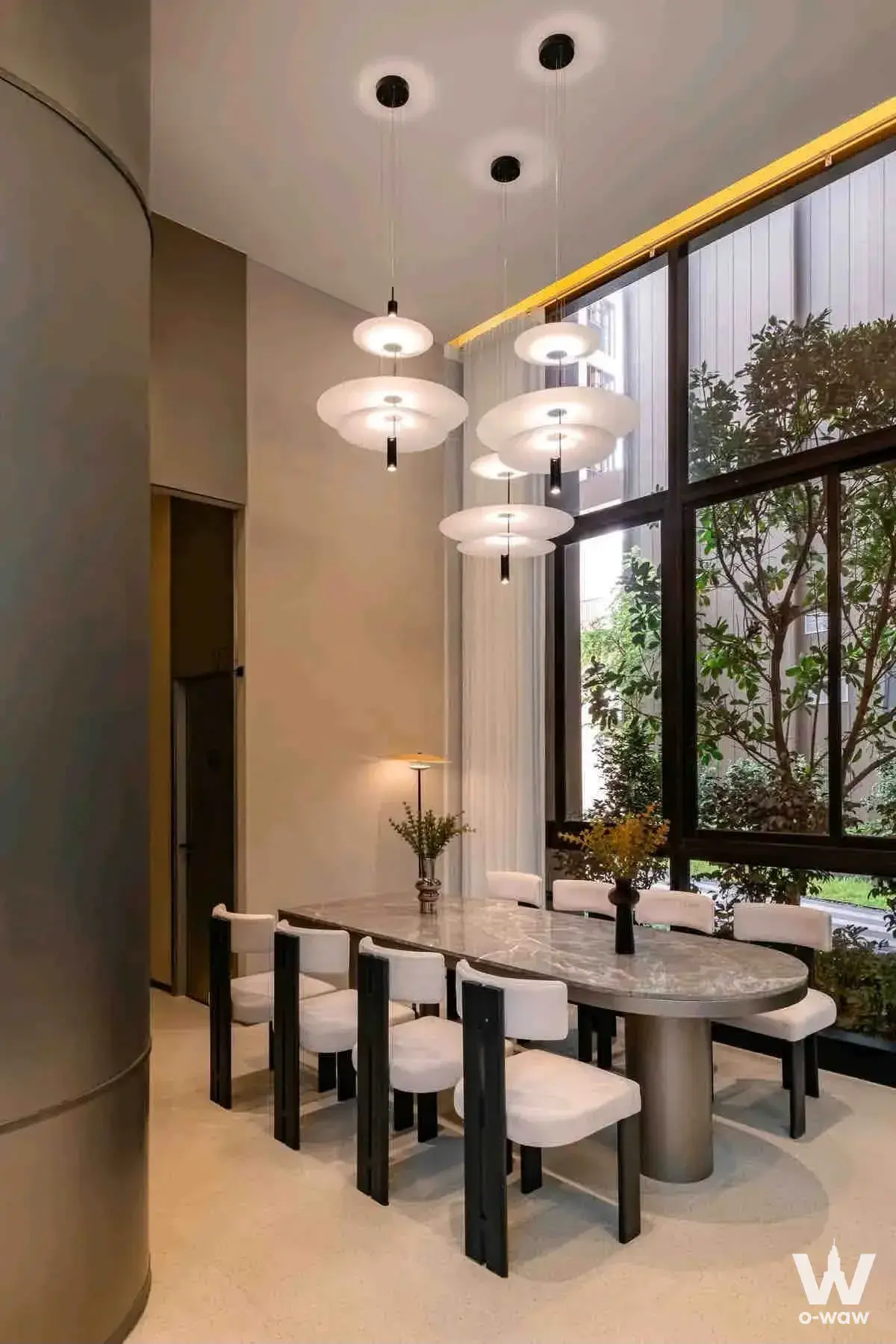 Dining room in Nue Riverest Ratburana condo with oval marble table and pendant lights